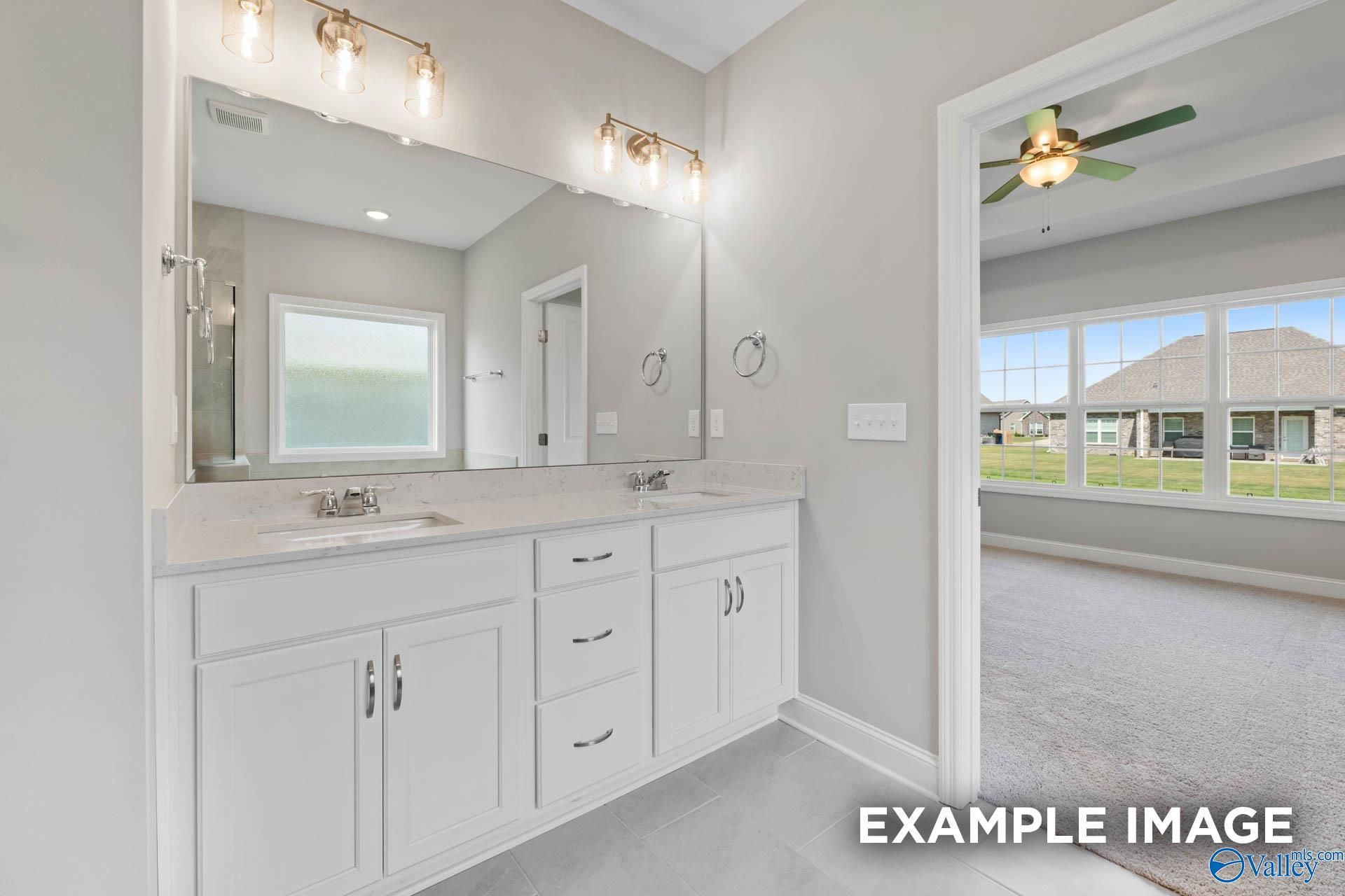 Elegant master bathroom with double vanity, white shaker cabinets, large mirror, and frosted window in Davidson Homes The Montgomery B, Hartselle, AL