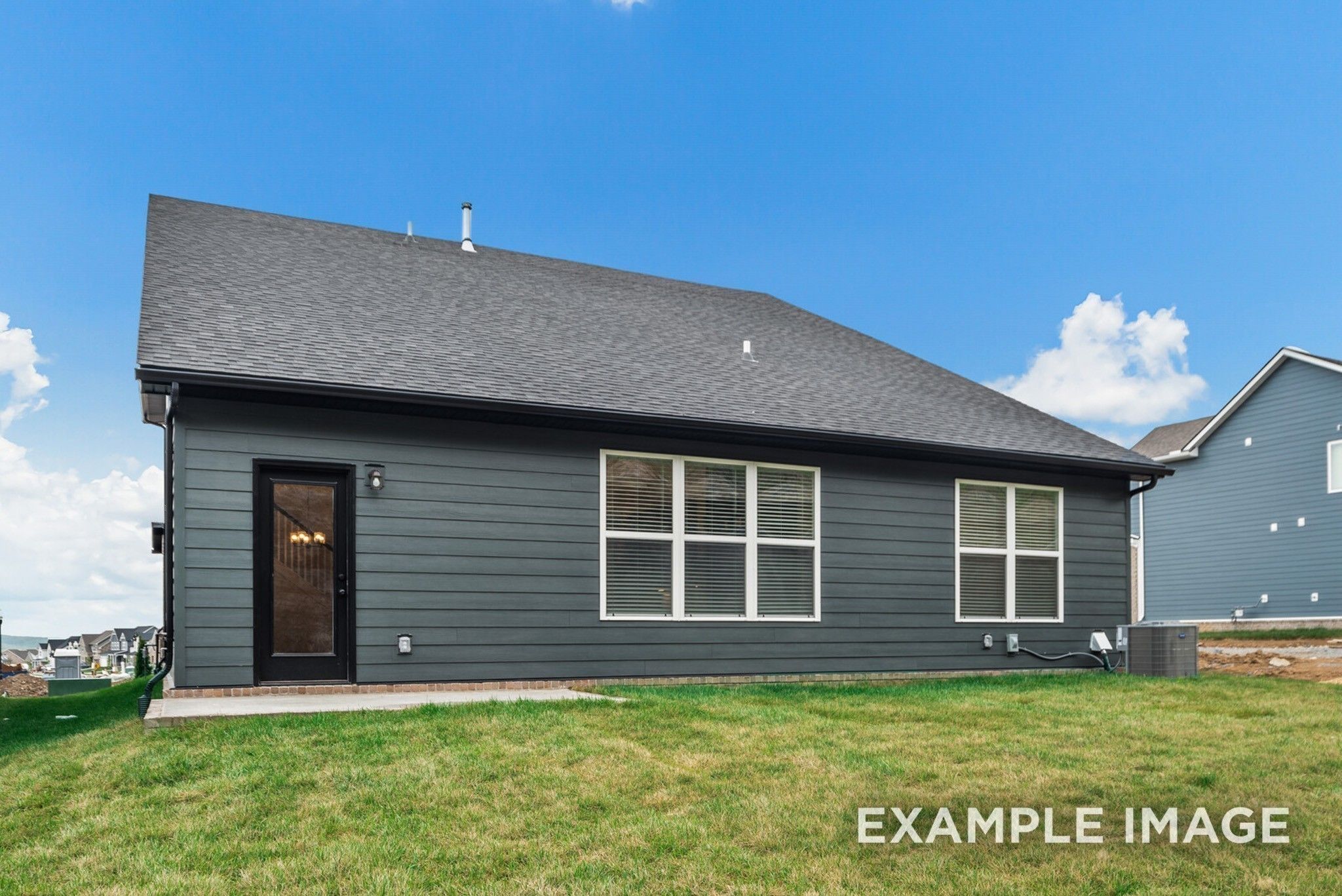 Gray-sided two-story home exterior with black entry door, large windows, and shingled roof in green yard, Davidson Homes Ridgeport C, Gallatin, TN