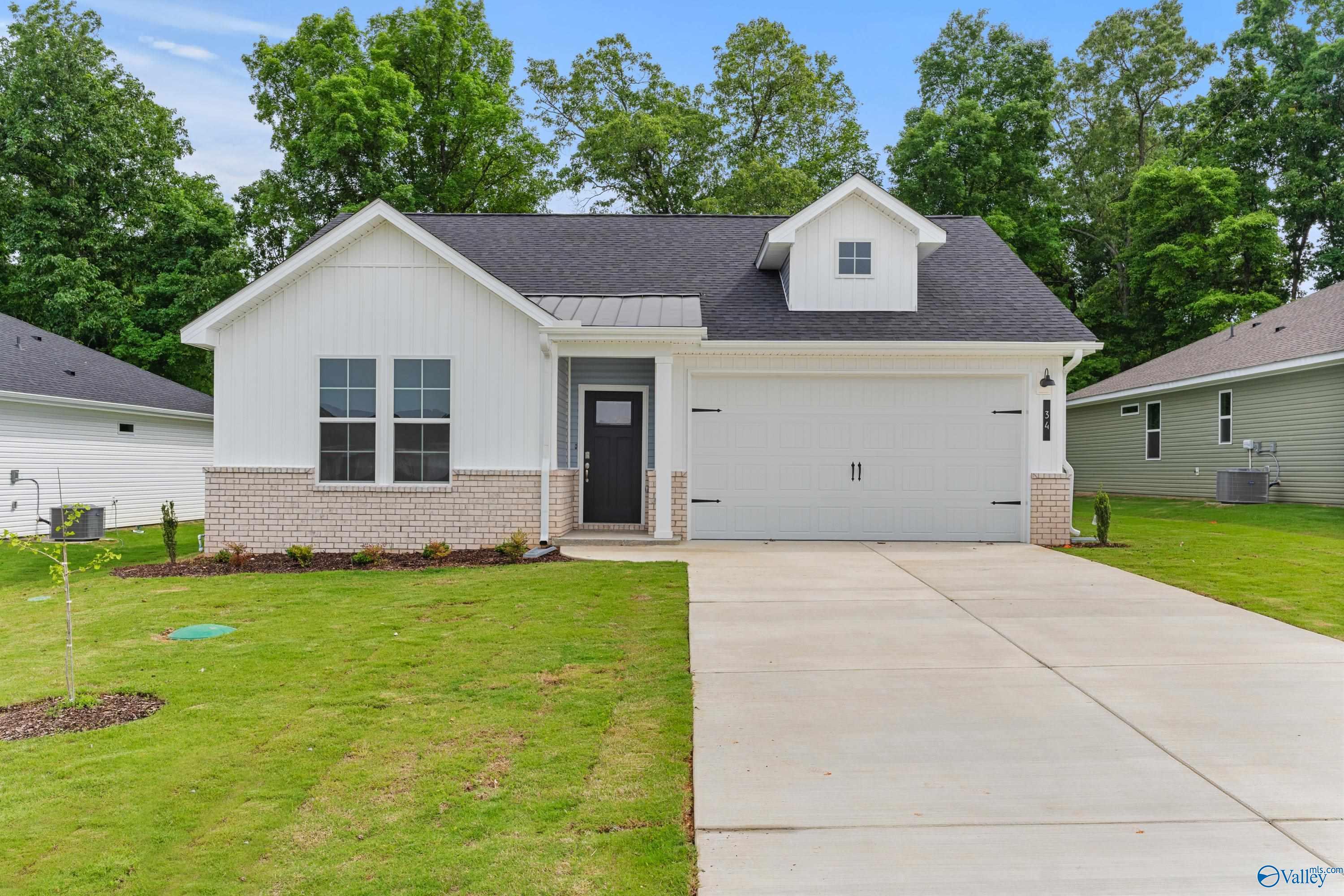 Modern white single-story home with black roof, 2-car garage, brick accents, and lush green yard in Bailey Park, Fayetteville, Tennessee