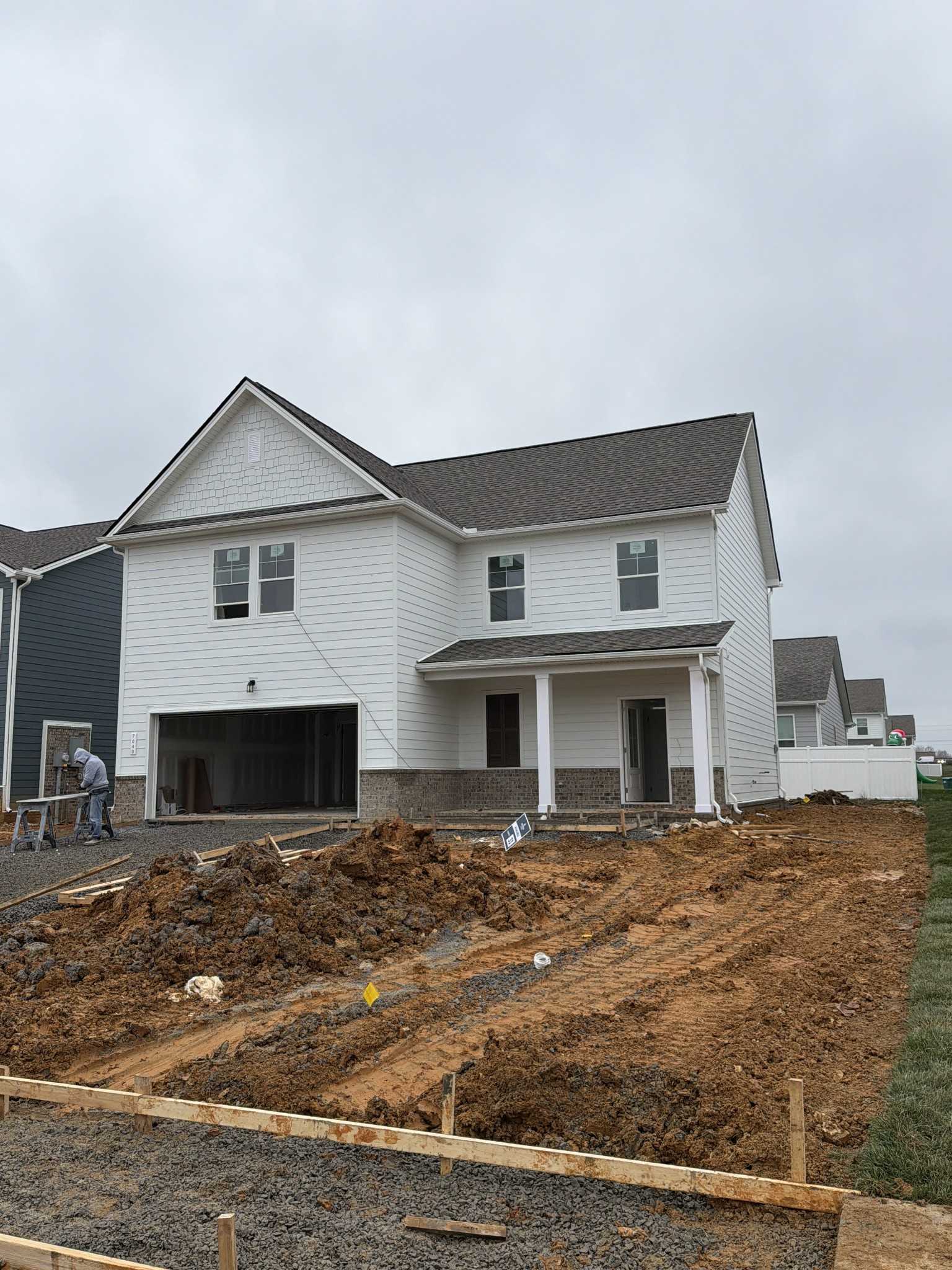 Two-story white Davidson Homes Gordon C with 2-car garage and front porch under construction in Sage Farms, White House, TN