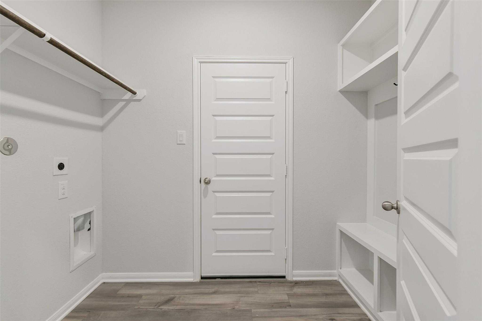 Functional laundry room with washer/dryer hookups, open shelves, bench, hooks in Davidson Homes The Frio G, Conroe, Texas