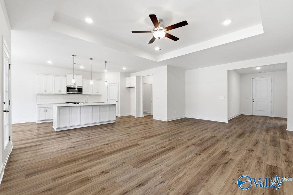 Modern open-concept kitchen with white cabinets, large island, and stainless appliances in The Montgomery floor plan, Hartselle, AL