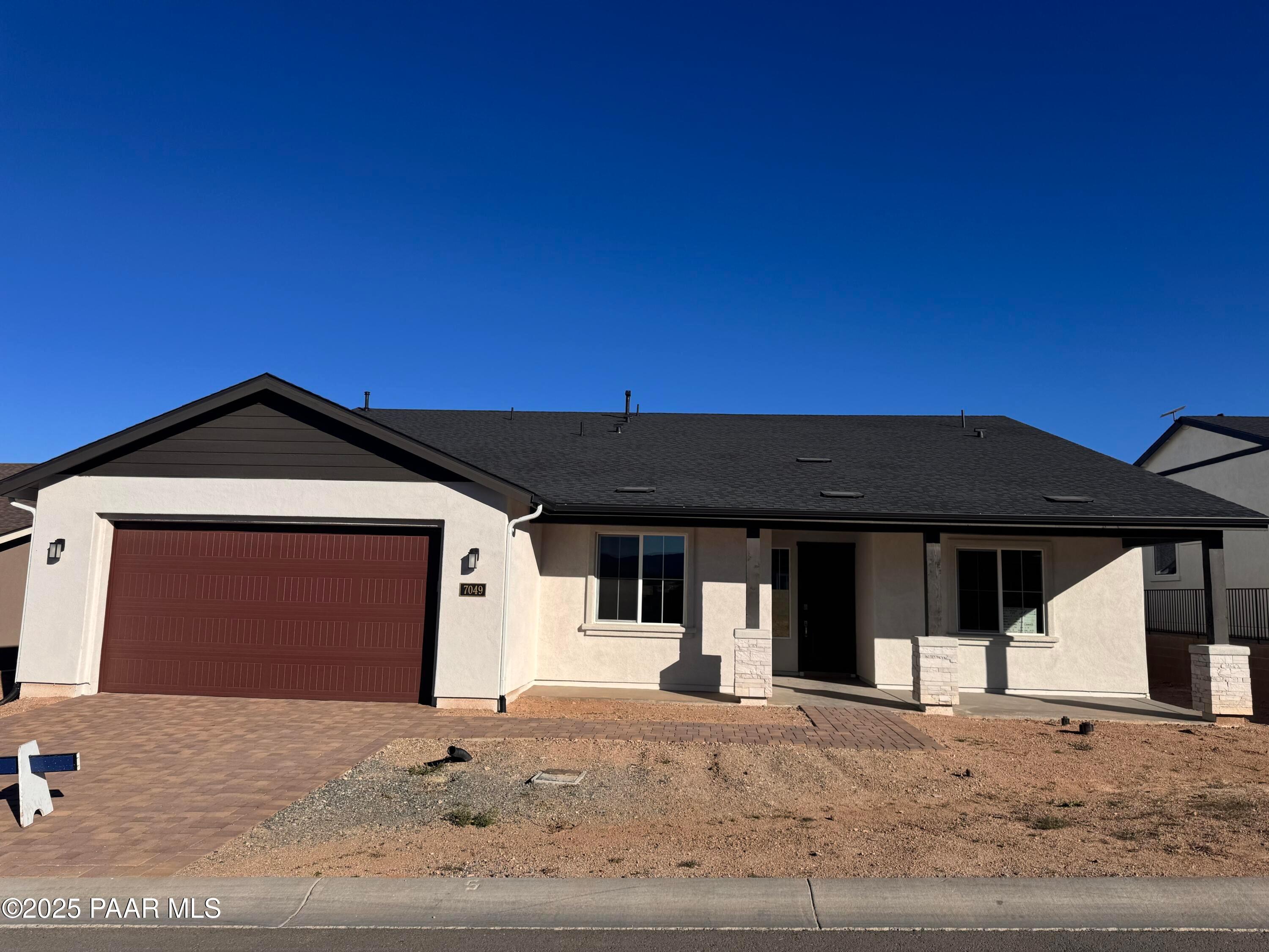 Modern single-story home with 3-car red garage, stucco exterior, paver driveway in Westwood, Prescott, Arizona by Davidson Homes