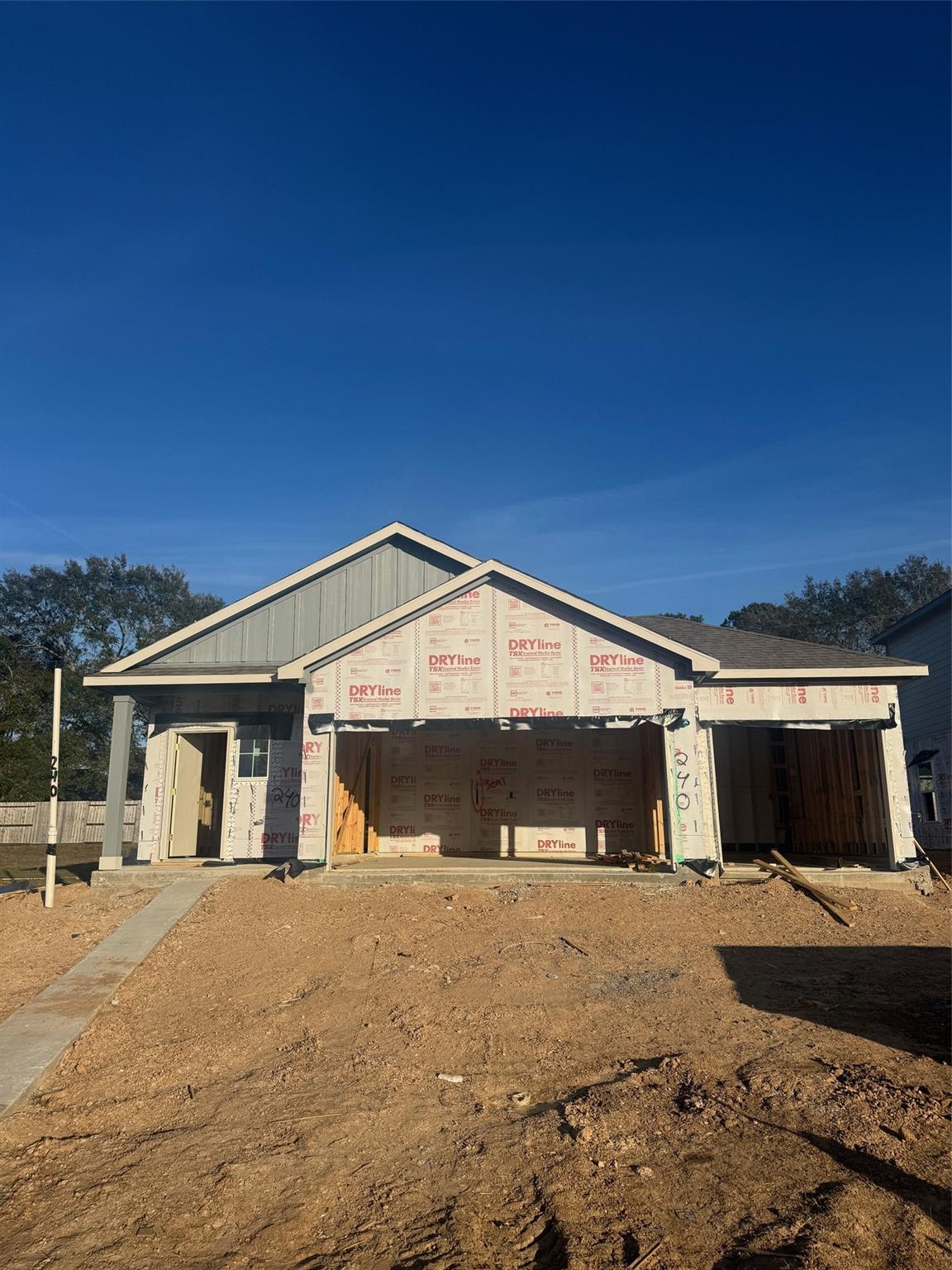 Framed 3-car garage and sheathed single-story home exterior in Windmill Estates, Magnolia, Texas by Davidson Homes The Frio F