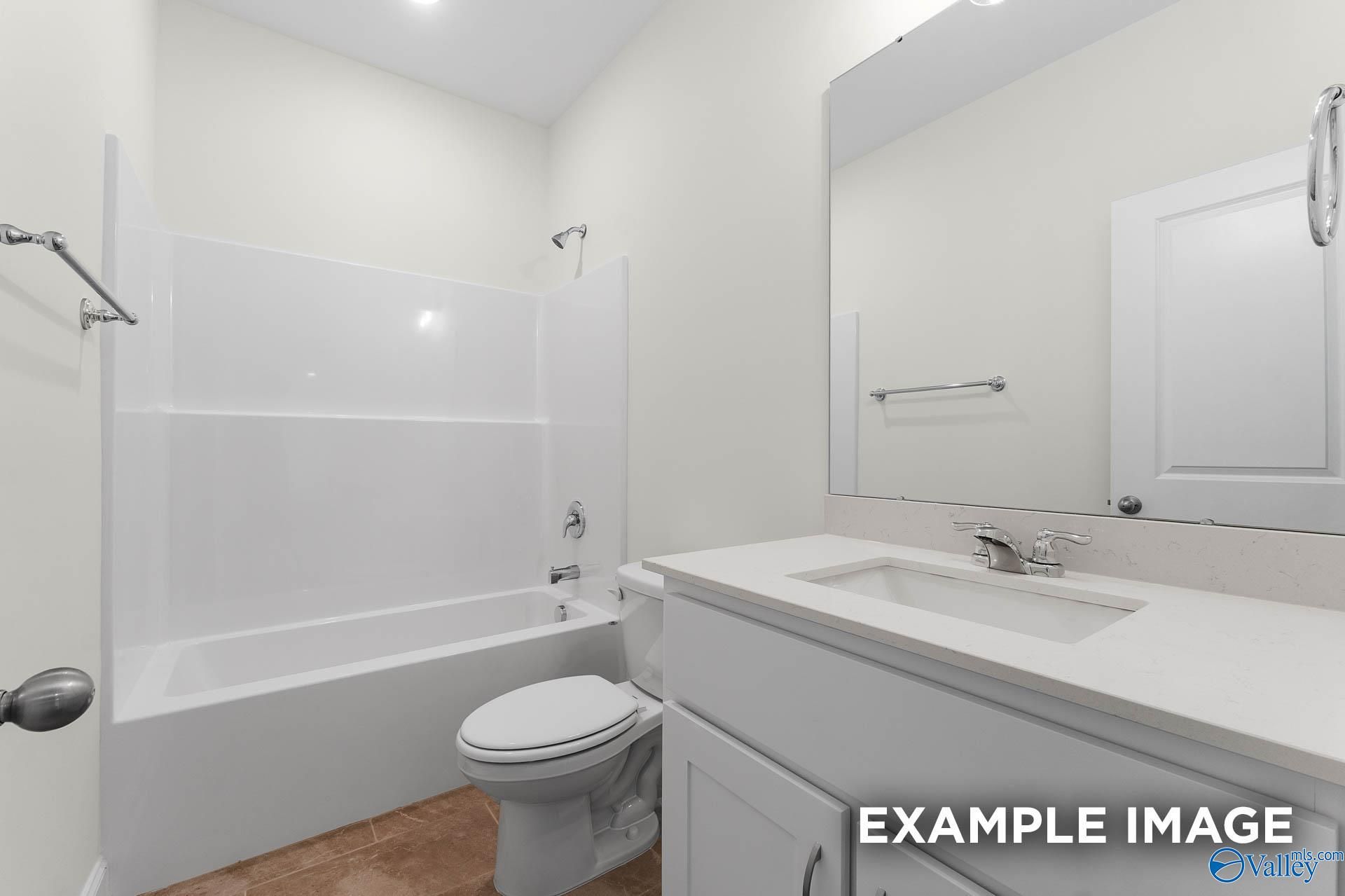 Bright bathroom with white tiled shower, soaking tub, vanity, and mirror in Davidson Homes The Emory, Toney, Alabama