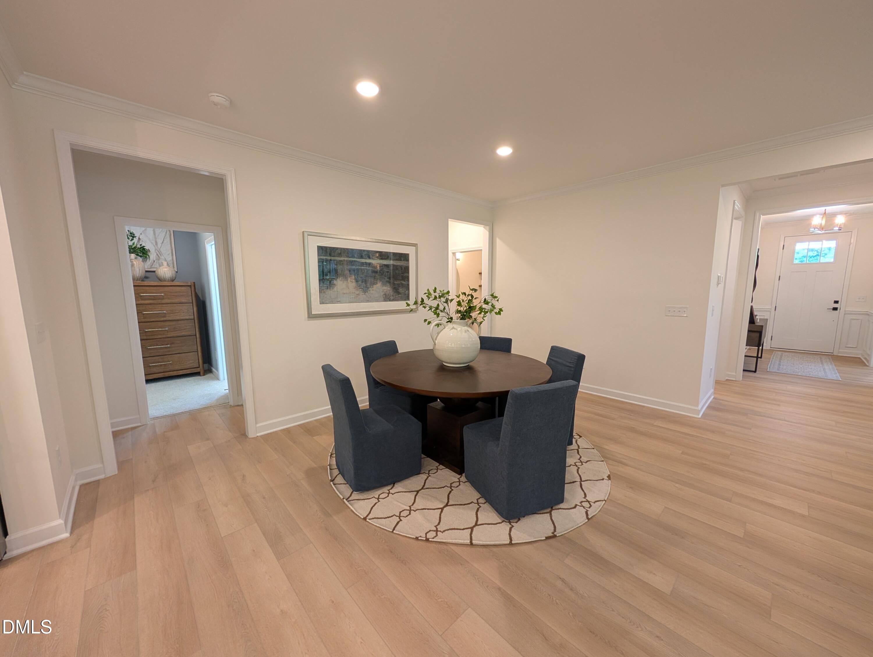 Formal dining area with round wood table and blue chairs in The Aspen B floor plan at Wendell Ridge, Wendell, NC.