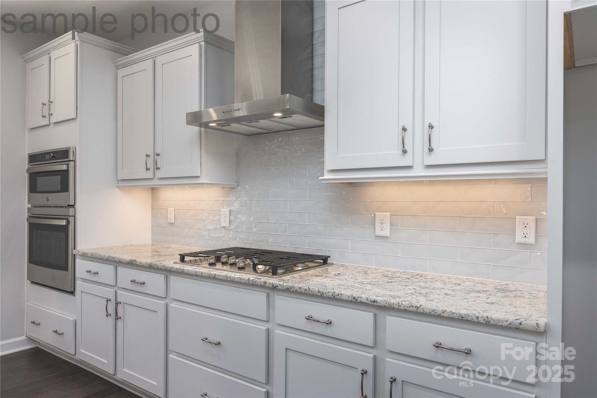 Bright kitchen with white shaker cabinets, granite counters, subway tile backsplash, stainless appliances in Davidson Homes Chestnut F, Belmont, NC