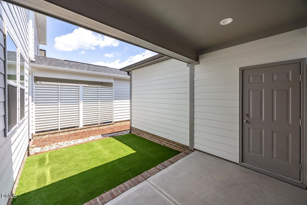 Covered patio with low-maintenance turf yard at The Alexander C floor plan in Forestville Yard, Knightdale, North Carolina.
