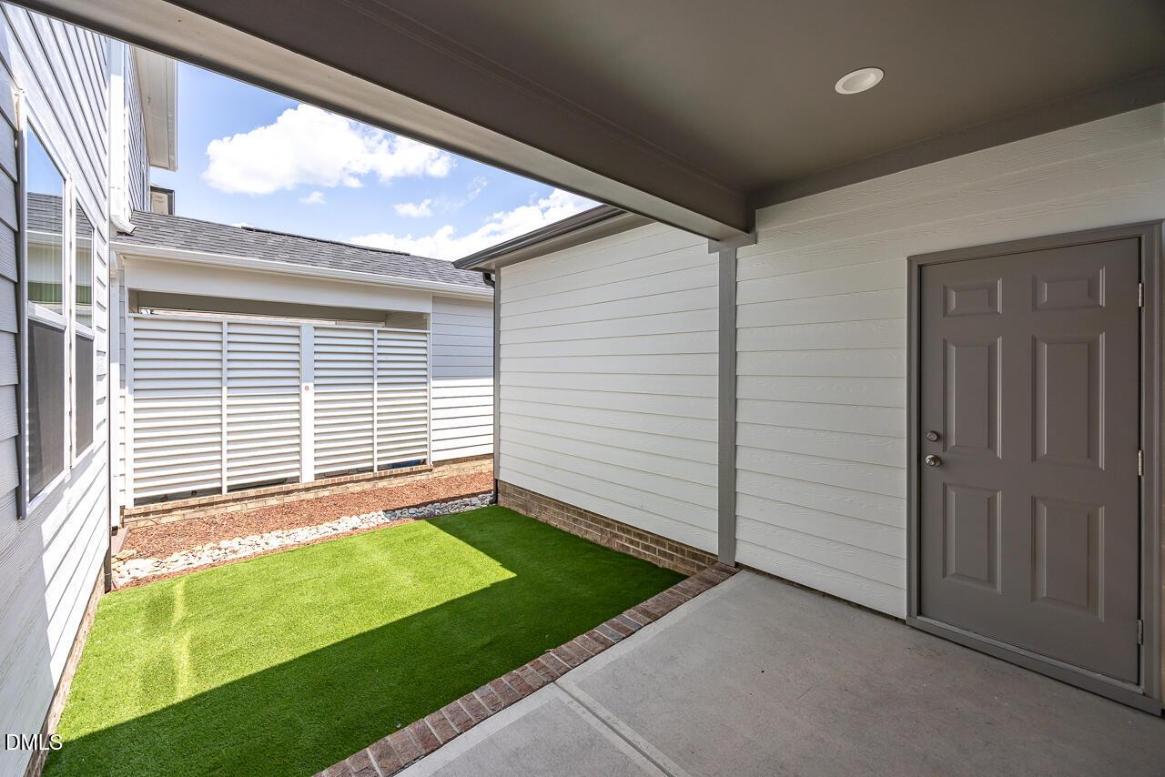 Covered patio with low-maintenance turf yard at The Alexander C floor plan in Forestville Yard, Knightdale, North Carolina.