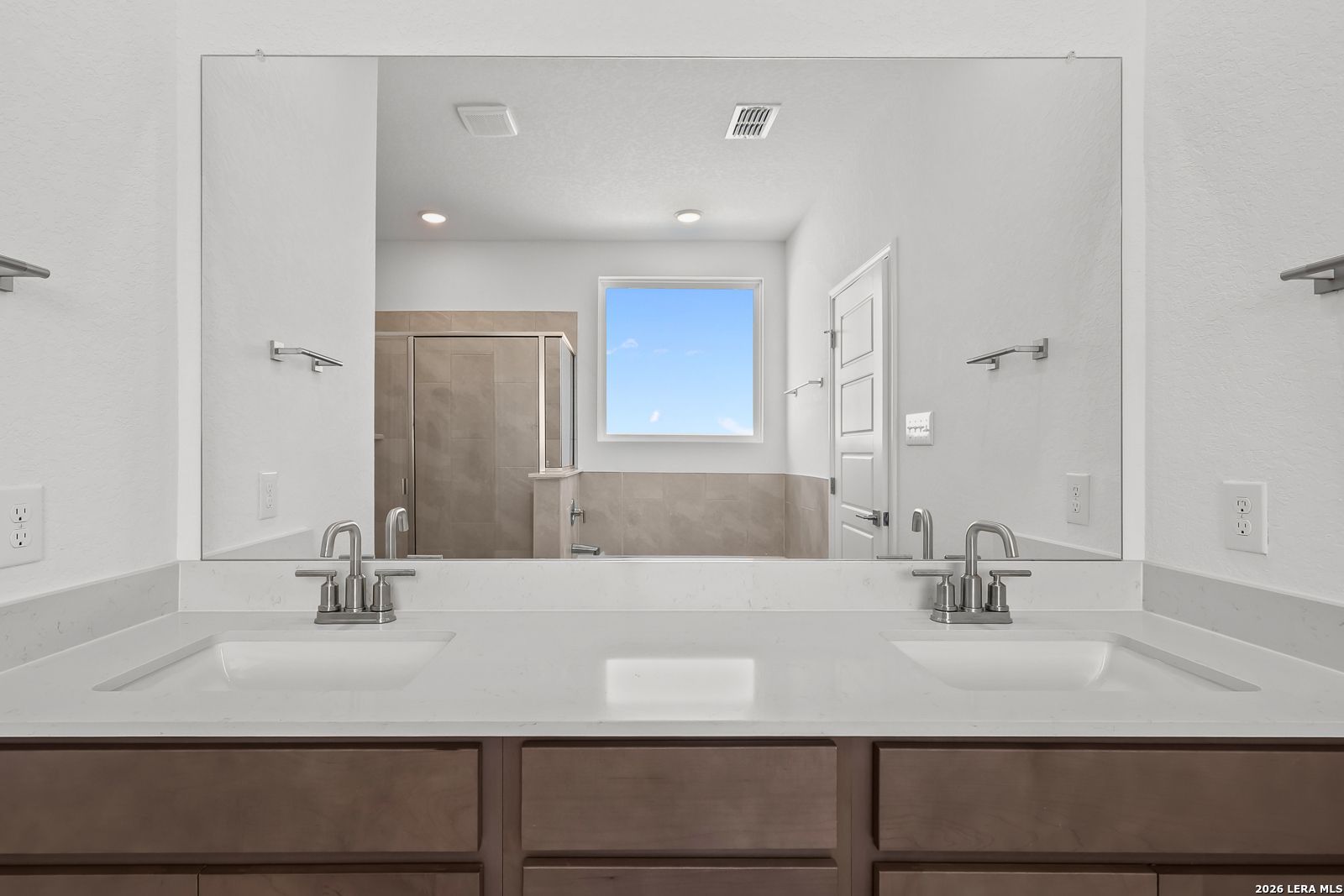 Spacious master bathroom with double vanity, quartz counters, walk-in shower, and natural light in Davidson Homes The Sequoia B, San Antonio