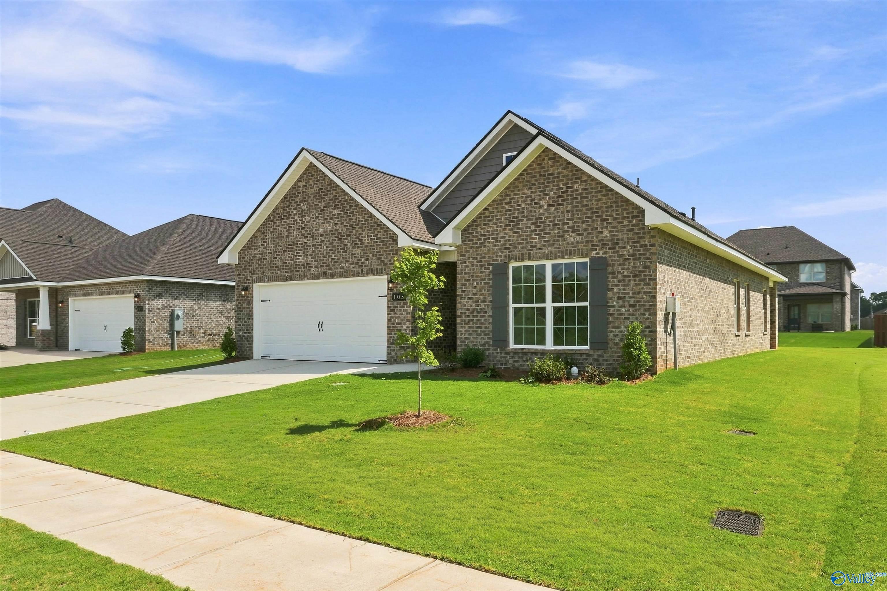 Brick exterior of Davidson Homes' Franklin C plan with 2-car garage and landscaped yard in Wood Trail, Toney, Alabama