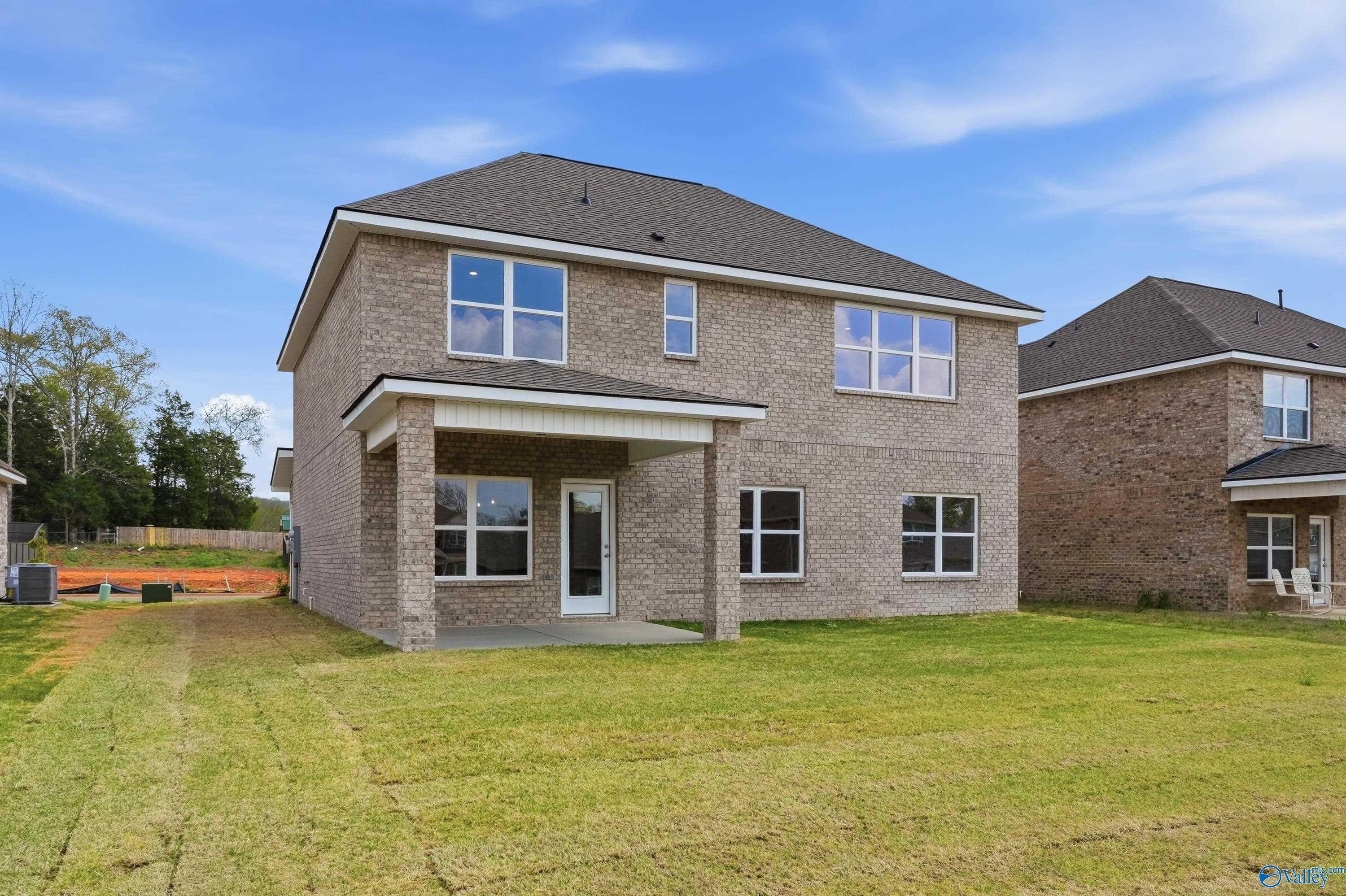 Two-story brick home with 2-car garage, covered front porch, and lush green yard in Creek Grove, New Market, Alabama - Davidson Homes Shelby B