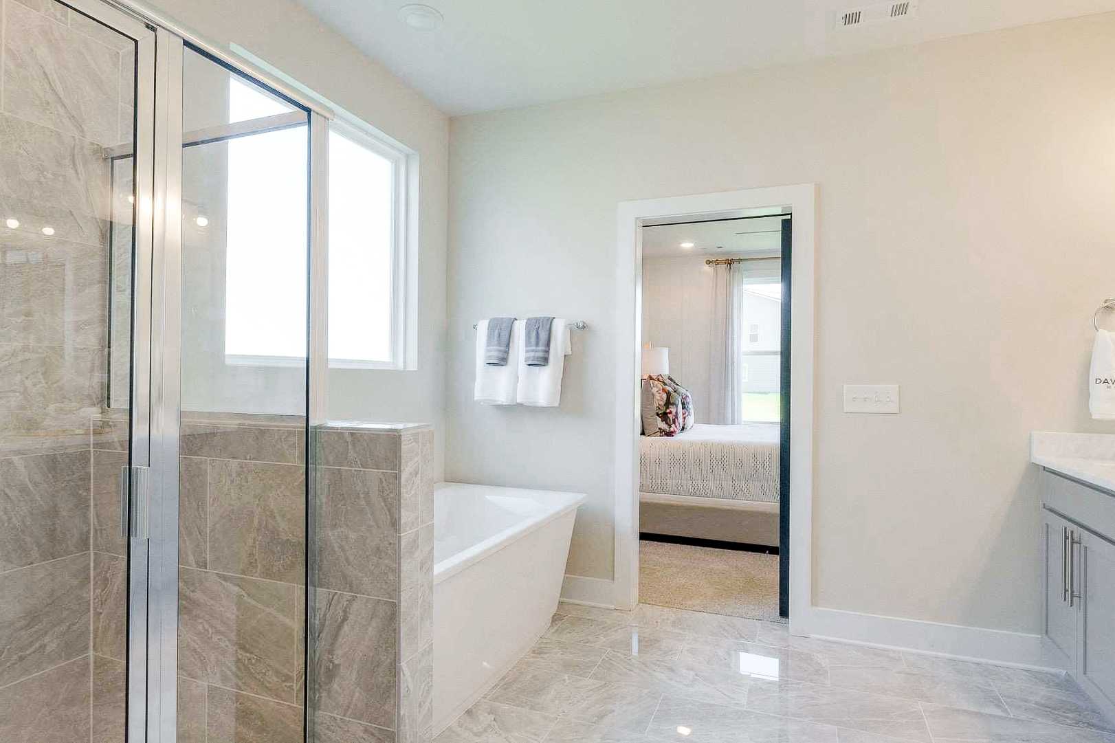Spa-like primary bathroom at The Meadows in Smyrna TN with glass shower, freestanding tub, and double vanity