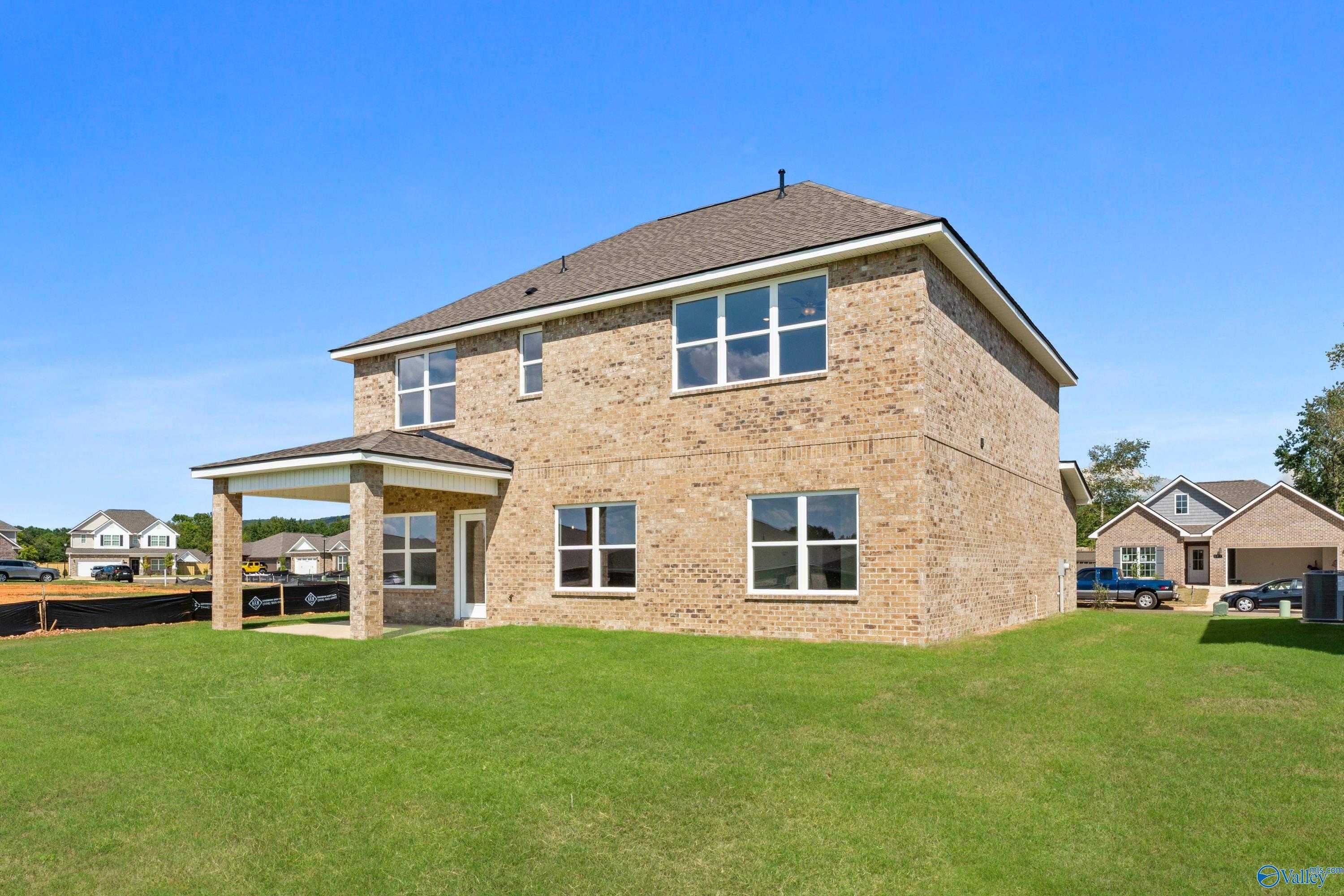 Two-story brick Shelby A home by Davidson Homes in Creek Grove, New Market, Alabama, with front porch, garage, and green lawn