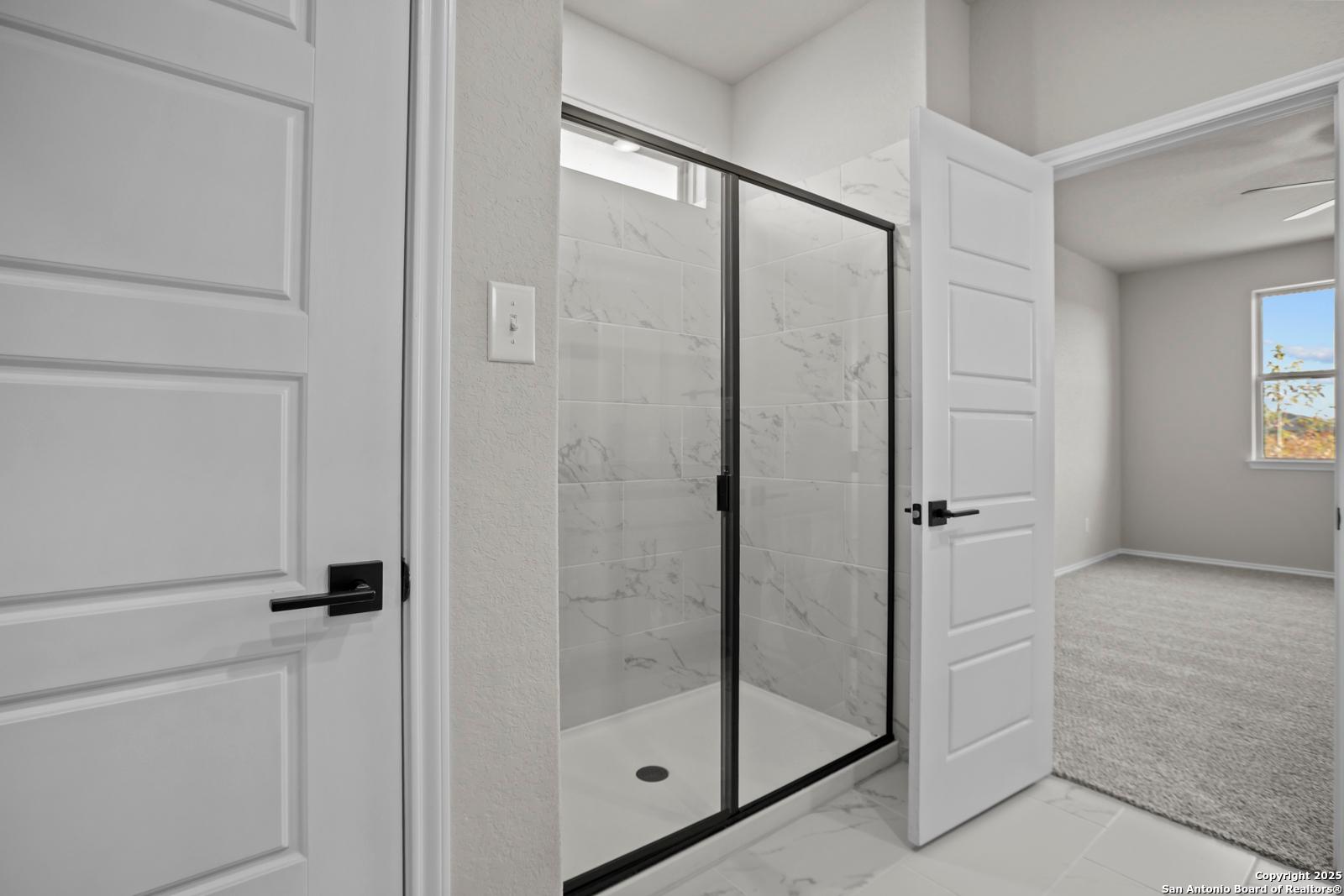 Modern walk-in shower with frameless glass door and subway tile walls in The Daphne H bathroom, Seguin, Texas