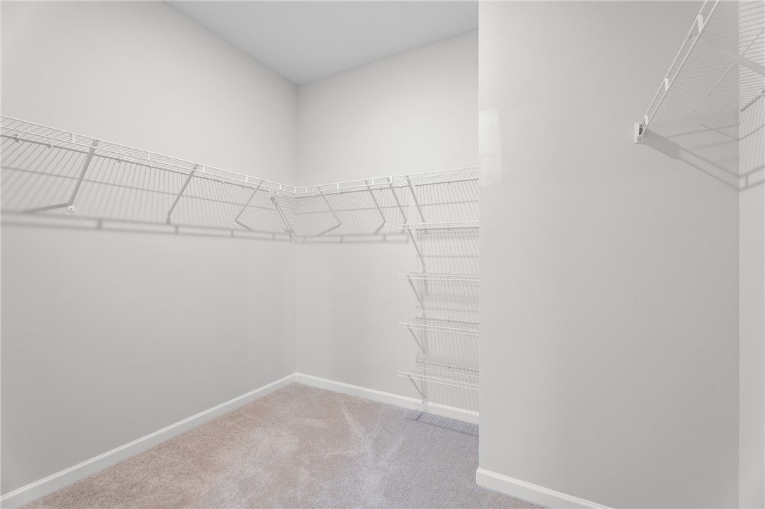 Spacious walk-in closet with white wire shelving and carpet flooring in Davidson Homes The Stella B, Opelika, Alabama