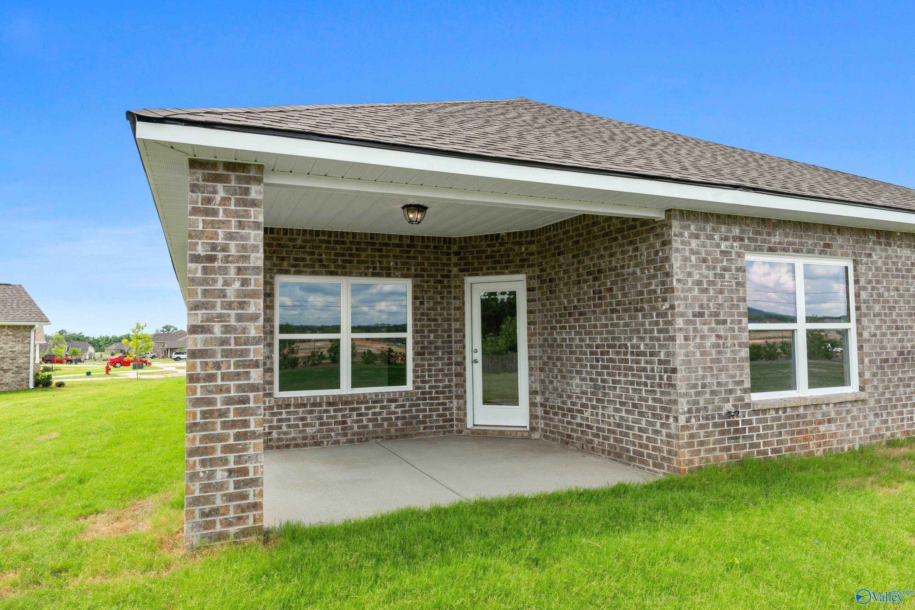 Covered brick patio and backyard of The Everett B floor plan by Davidson Homes in The Meadows, Athens, Alabama.