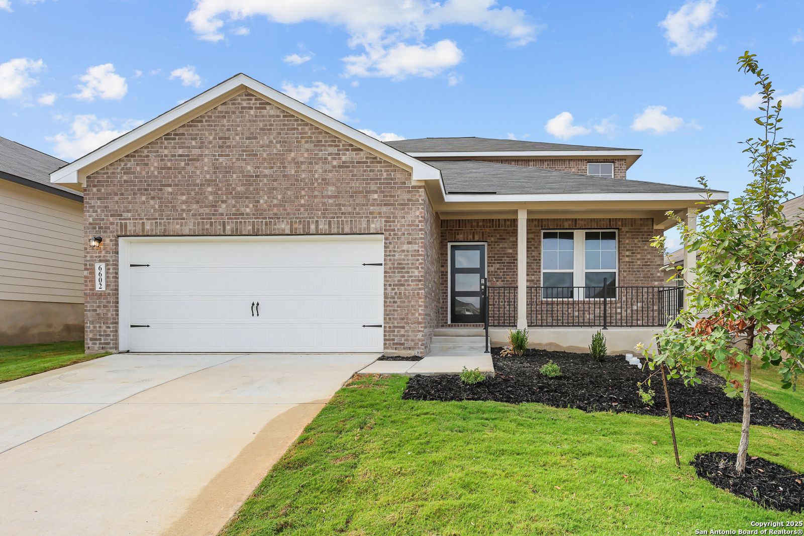 Modern 2-story brick home with 2-car garage, covered porch, and lush lawn in Royal Crest, San Antonio, Texas by Davidson Homes The Douglas G