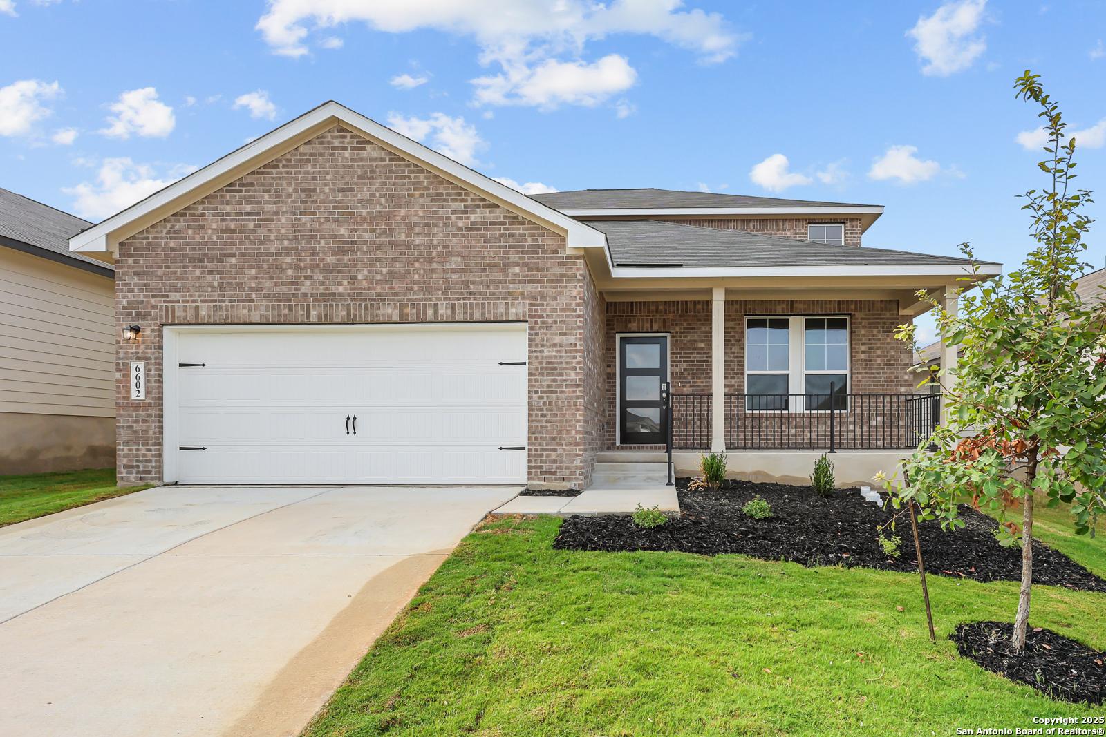 Modern 2-story brick home with 2-car garage, covered porch, and lush lawn in Royal Crest, San Antonio, Texas by Davidson Homes The Douglas G