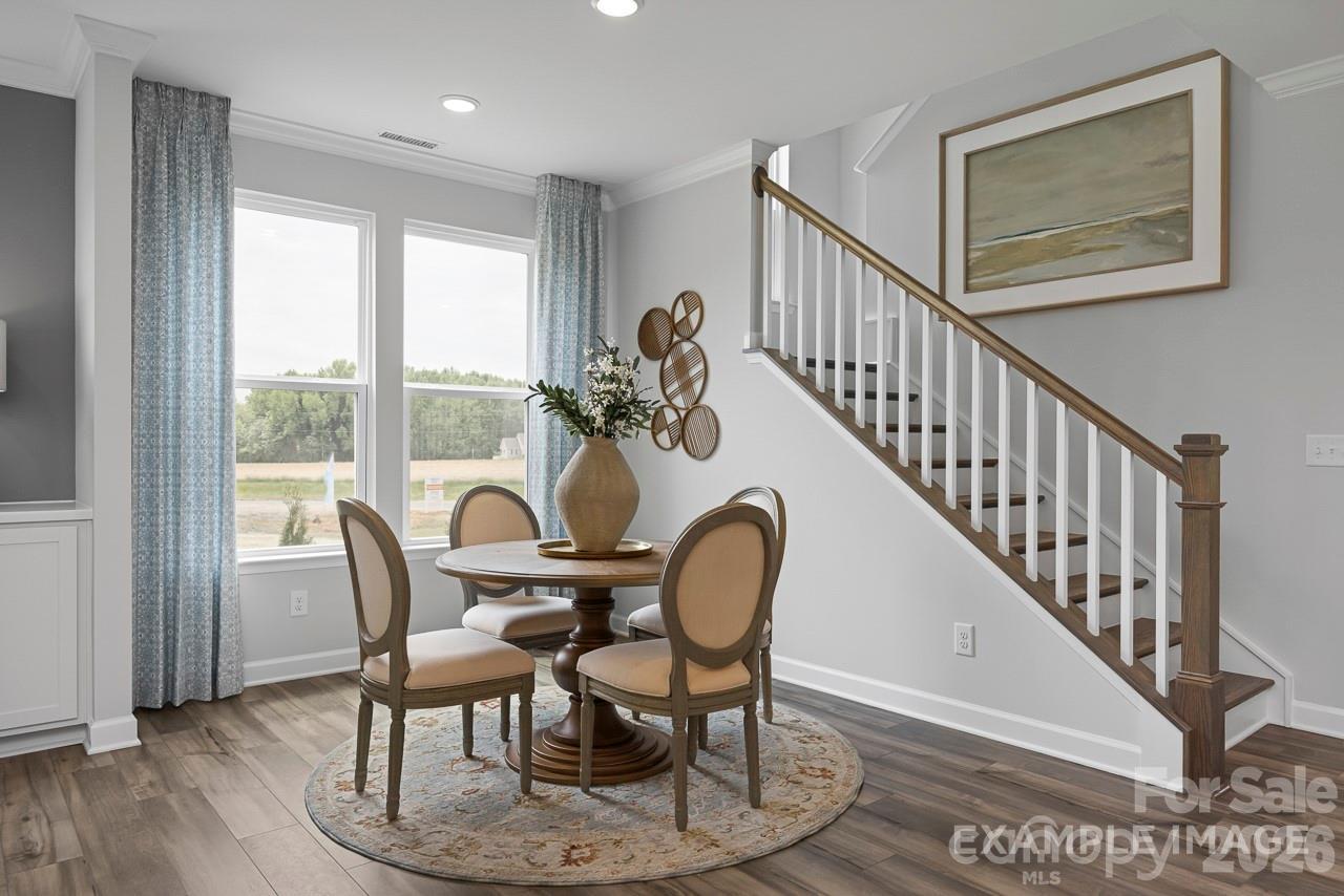 Bright breakfast nook with dining set and staircase in The Magnolia A floor plan at Windgate in Mooresville, NC.