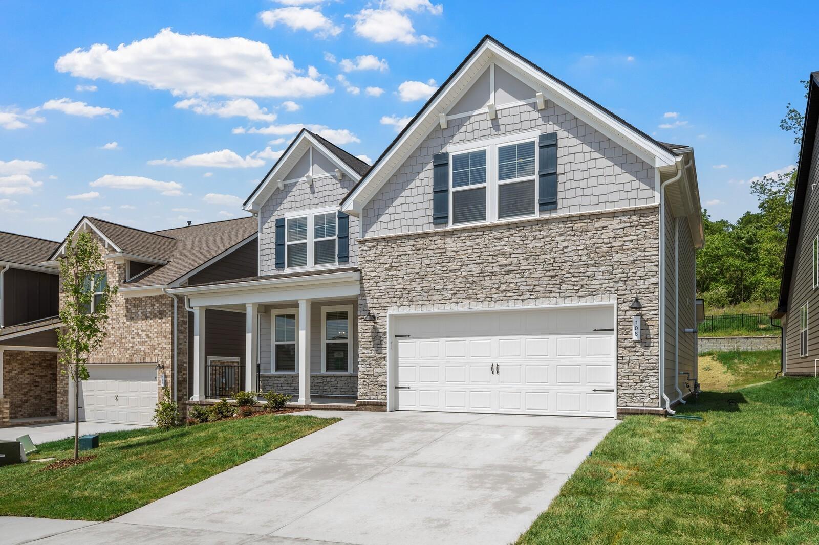 Two-story Willow floor plan home by Davidson Homes with stone facade and 2-car garage in Woods Crossing, Gallatin, TN.
