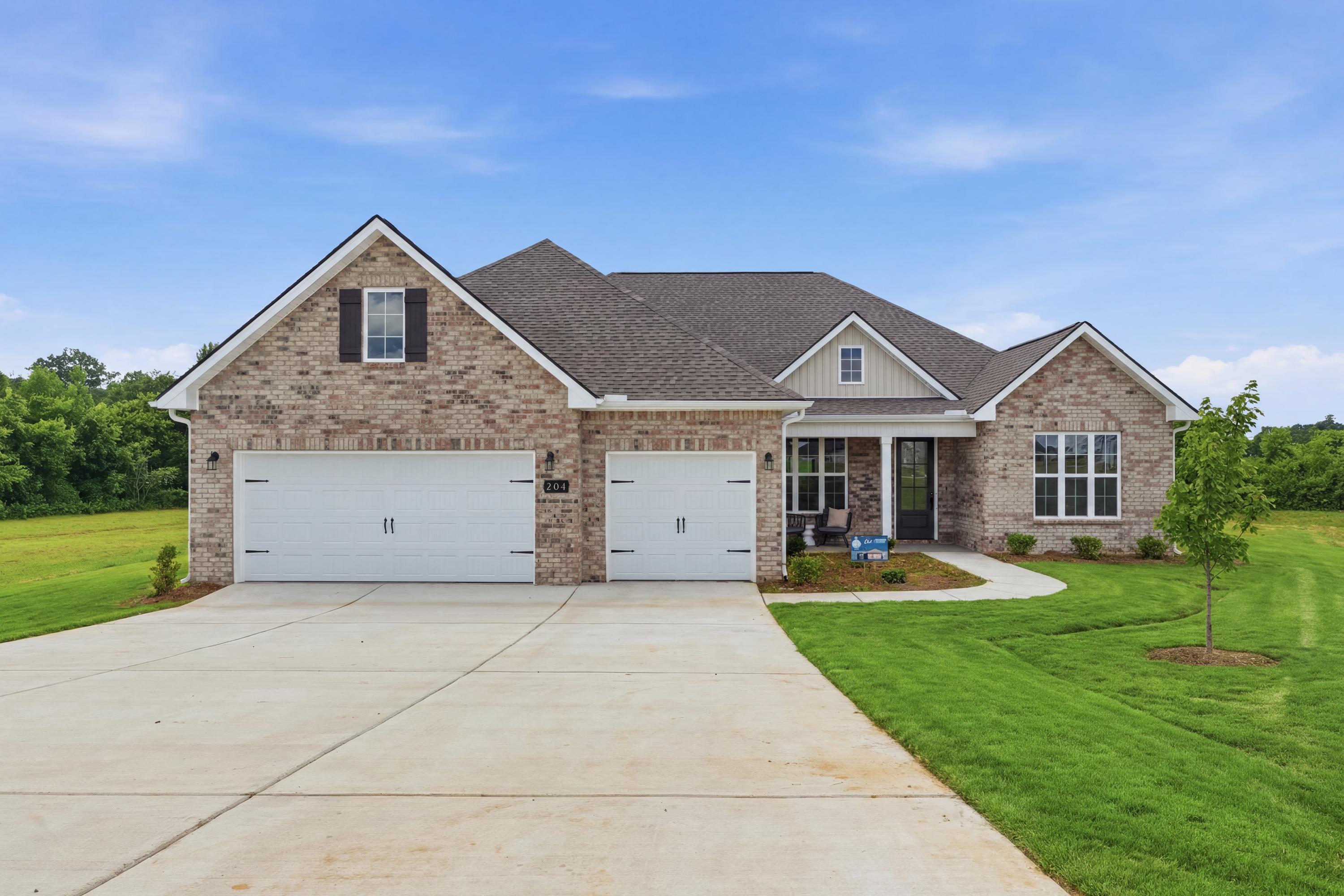Brick exterior of a Davidson Homes house at Riverton Preserve in Huntsville, Alabama with a three-car garage and lawn.