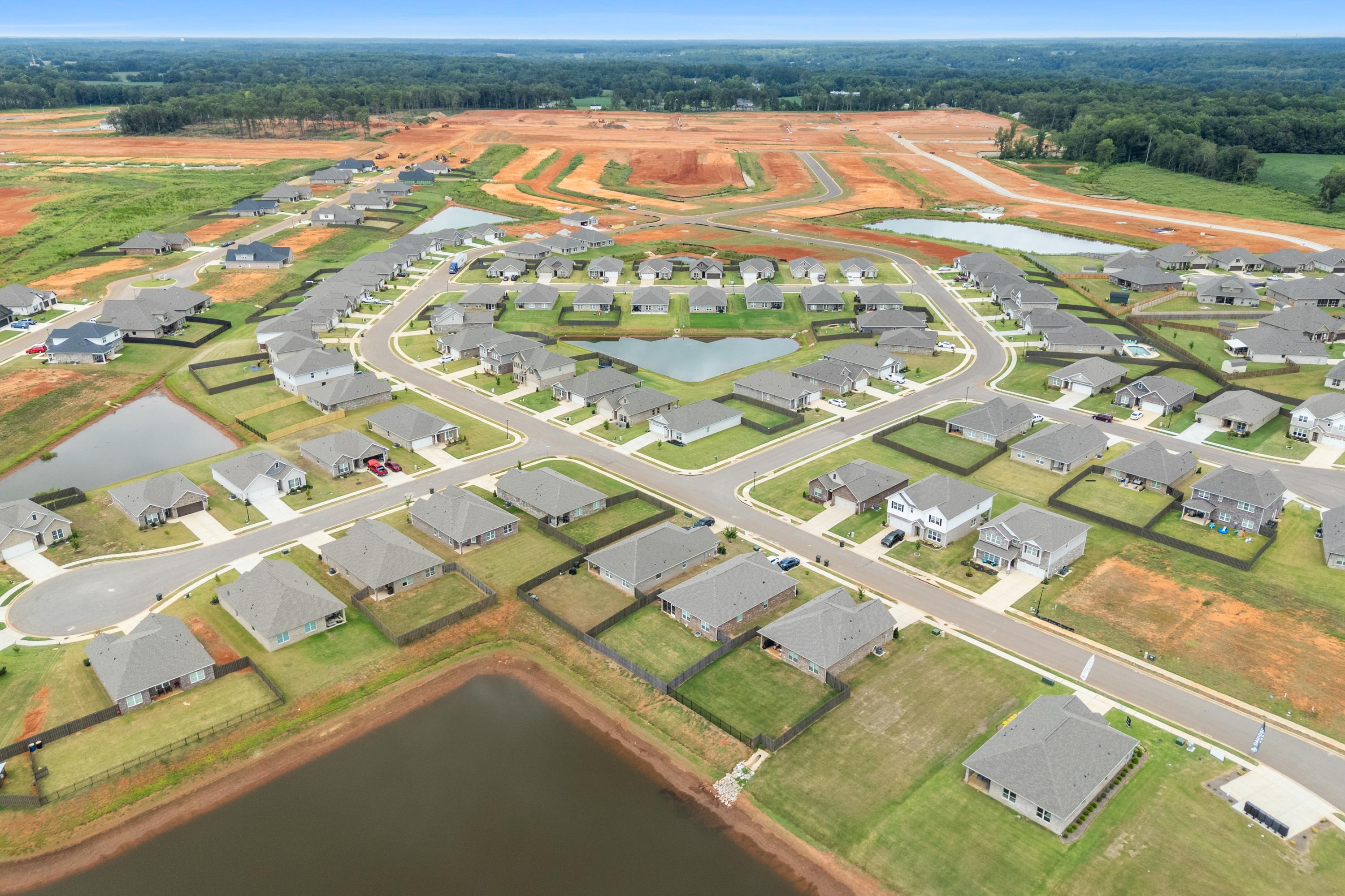 Aerial view of Heritage Lakes in New Market Alabama featuring new Davidson Homes ponds green spaces and construction