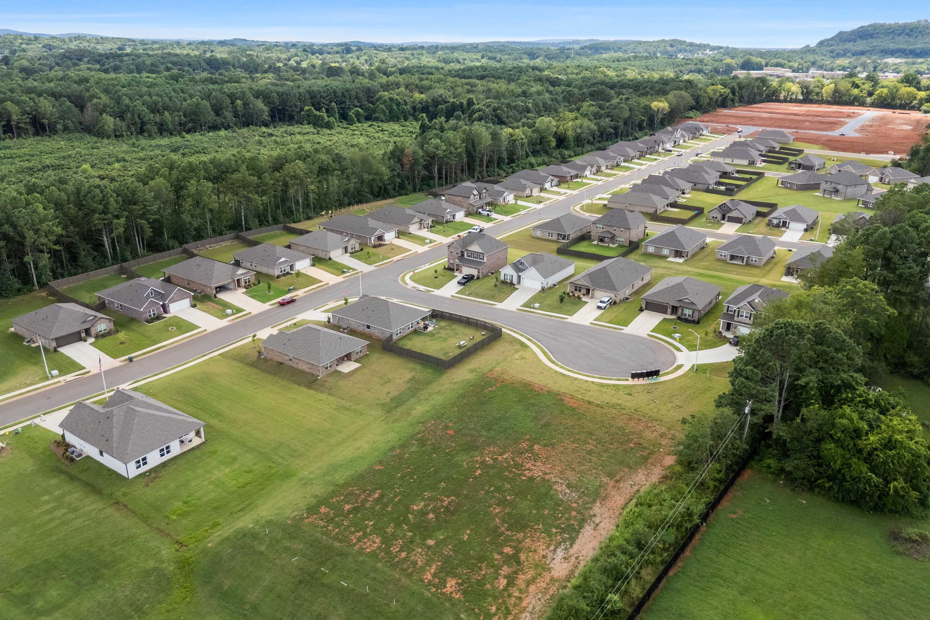 Aerial view of new Davidson Homes in Blue Spring neighborhood, Huntsville AL, surrounded by lush forests and green lawns