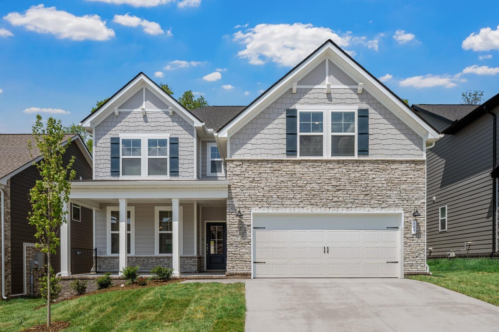 Two-story Willow floor plan home with stone facade and two-car garage at Woods Crossing in Gallatin, Tennessee.
