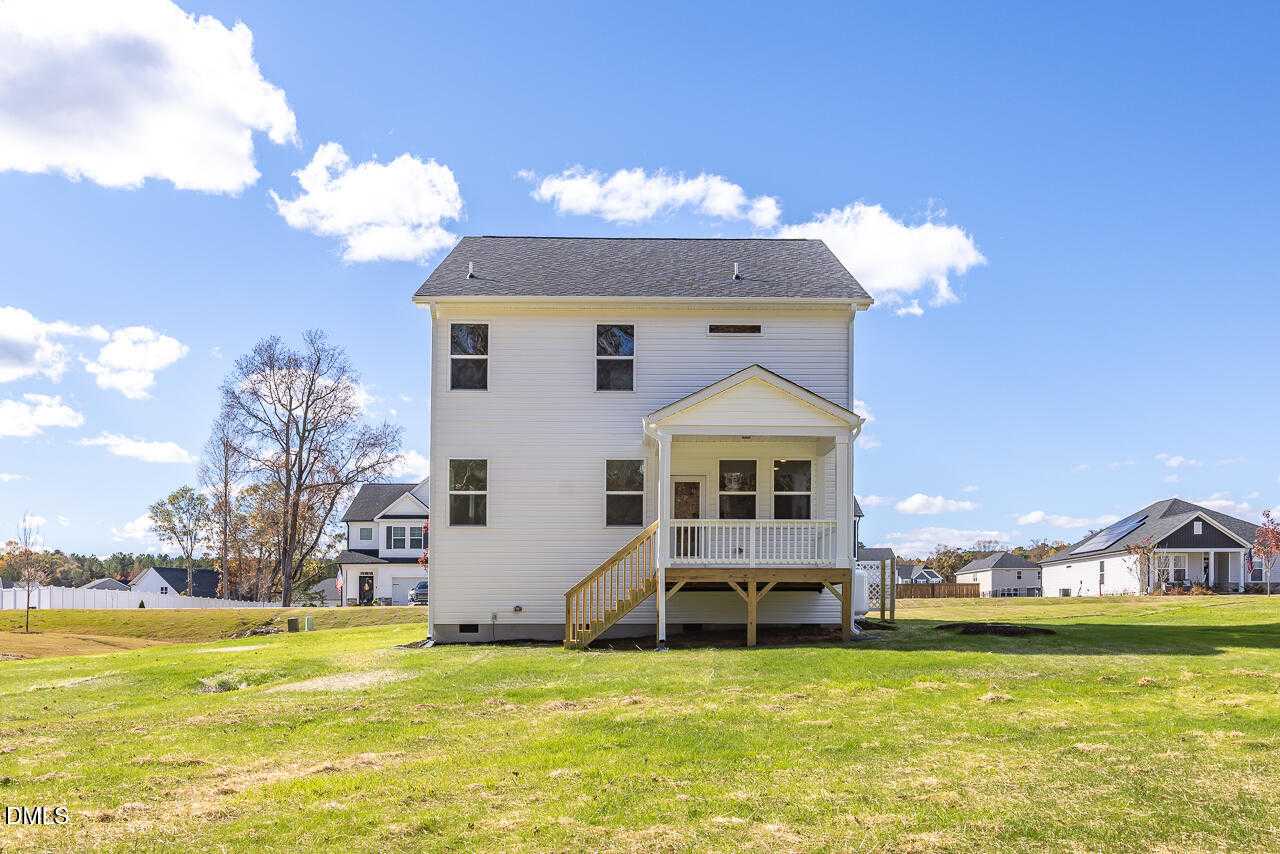 Two-story white Gavin C home with covered back porch, stairs, and green yard in Wellers Knoll, Lillington, North Carolina