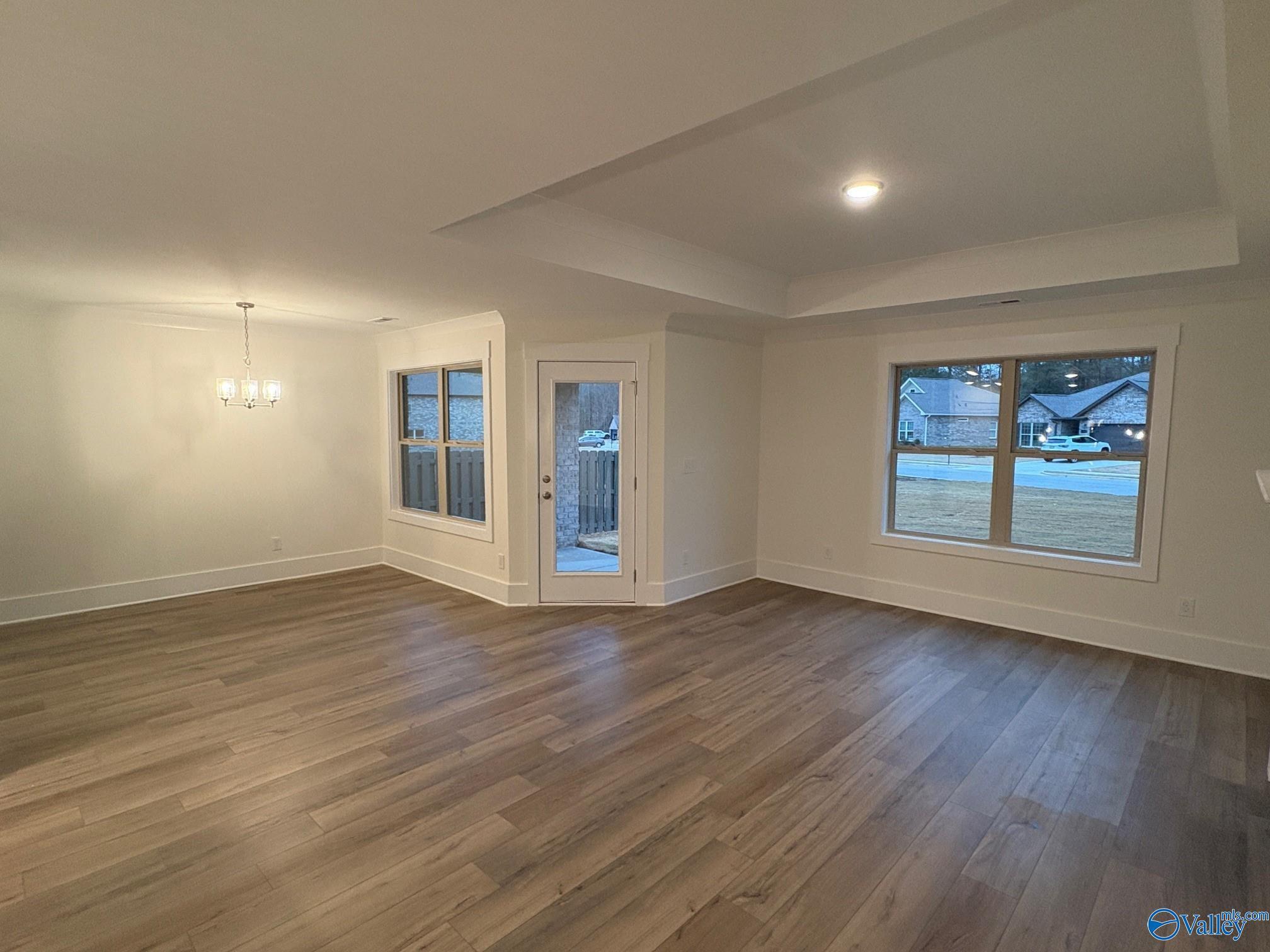 Bright formal dining room with hardwood floors, chandelier, and French doors to patio in Davidson Homes The Daphne C, Arab, Alabama