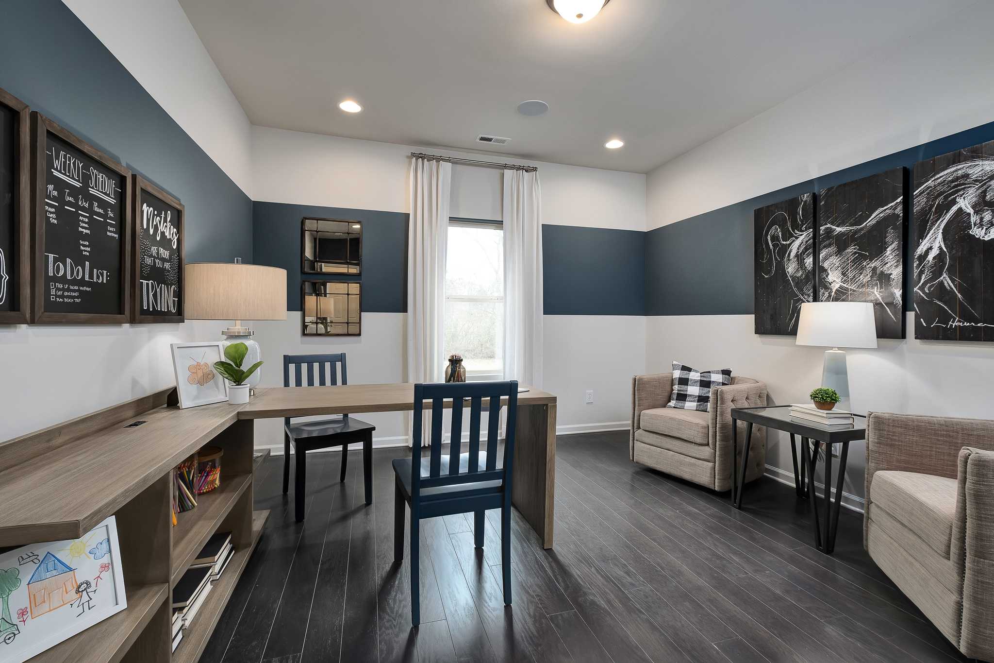 Spacious home office at The Reserve at Overton in Hampton Cove AL with navy accent wall, built-in desk, and plush seating