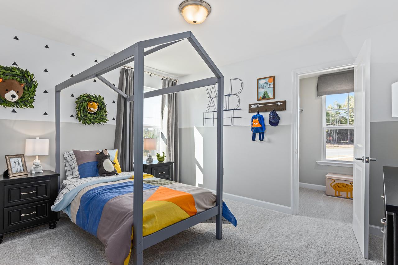 Whimsical kid's bedroom in The Hemlock home design featuring a gray house-frame bed and playful woodland decor.