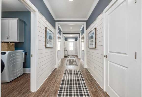 impressive hallway with shiplap walls and crown molding by Davidson Homes