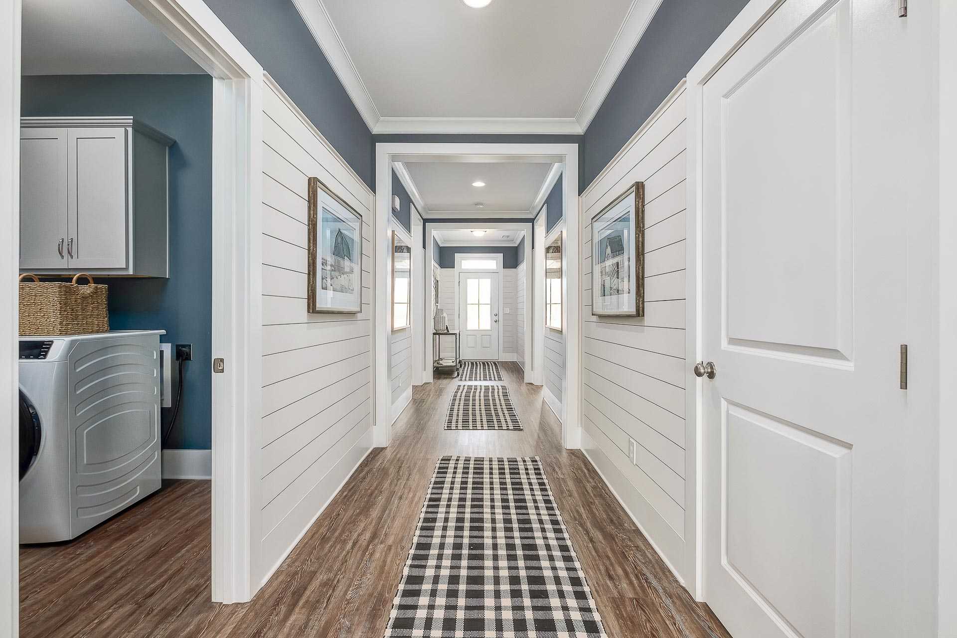 impressive hallway with shiplap walls and crown molding by Davidson Homes