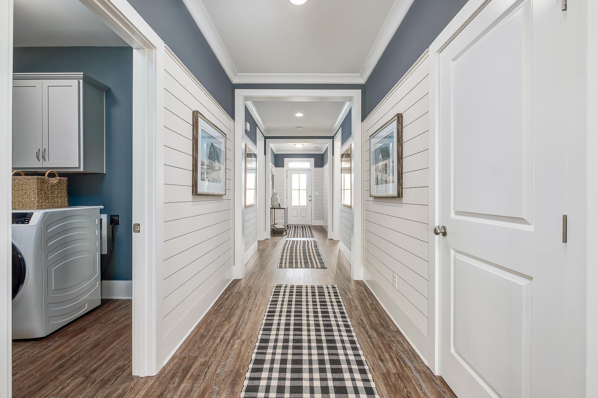 impressive hallway with shiplap walls and crown molding by Davidson Homes