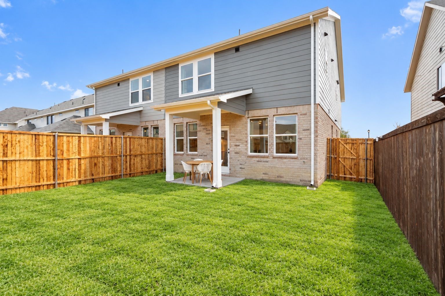 Backyard with covered patio and lush green lawn at Davidson Homes' The Wake C in Lake Park Villas, Wylie, Texas