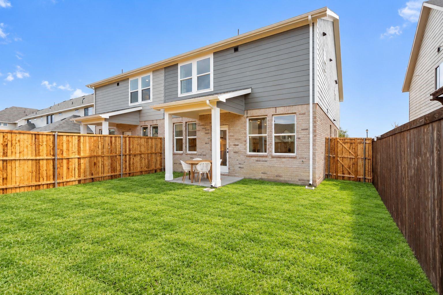 Backyard with covered patio and lush green lawn at Davidson Homes' The Wake C in Lake Park Villas, Wylie, Texas
