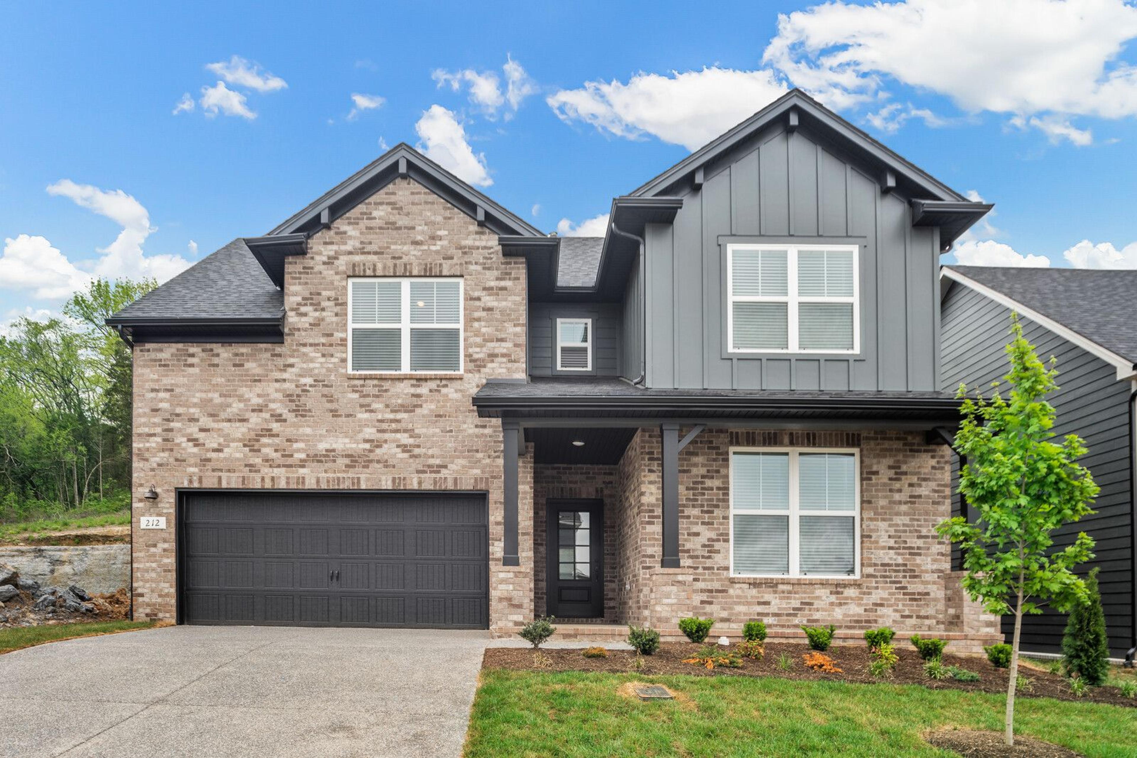 Spacious modern kitchen at Woods Crossing in Gallatin TN with white shaker cabinets, stainless appliances, and gray island bar seating