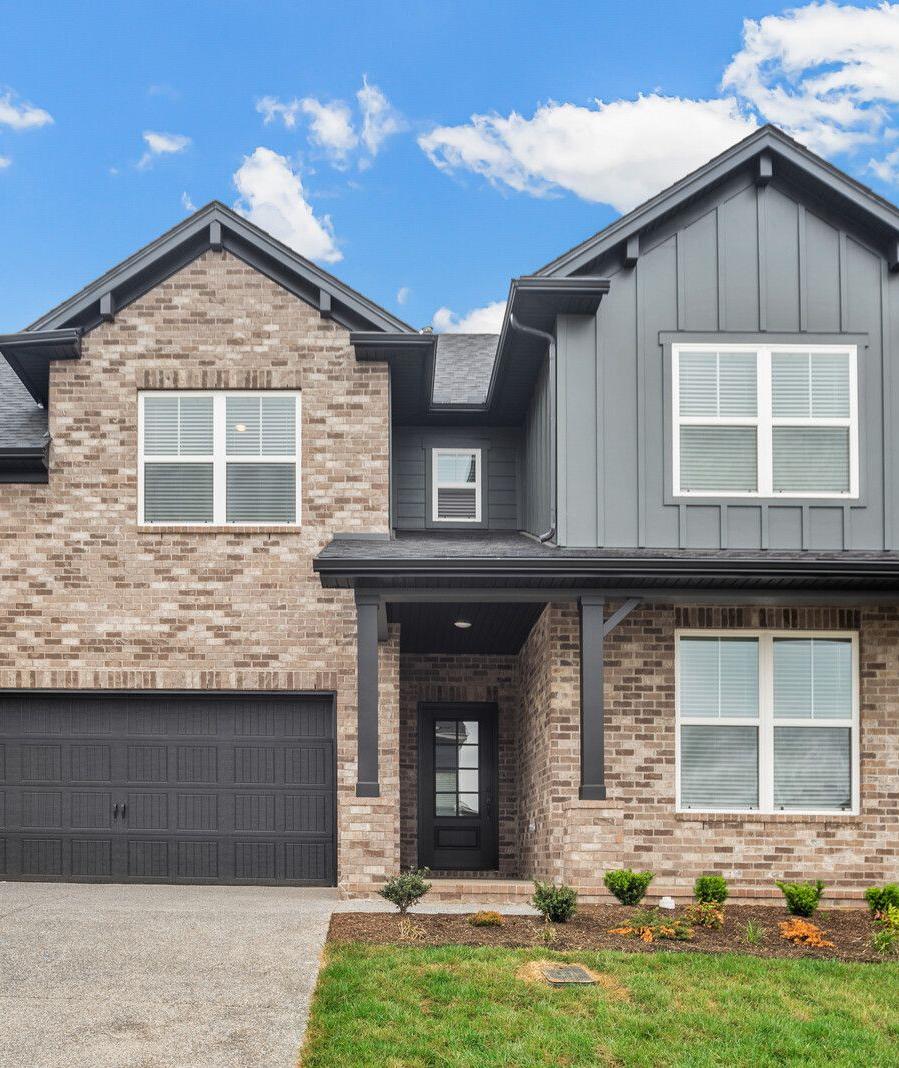 Spacious modern kitchen at Woods Crossing in Gallatin TN with white shaker cabinets, stainless appliances, and gray island bar seating