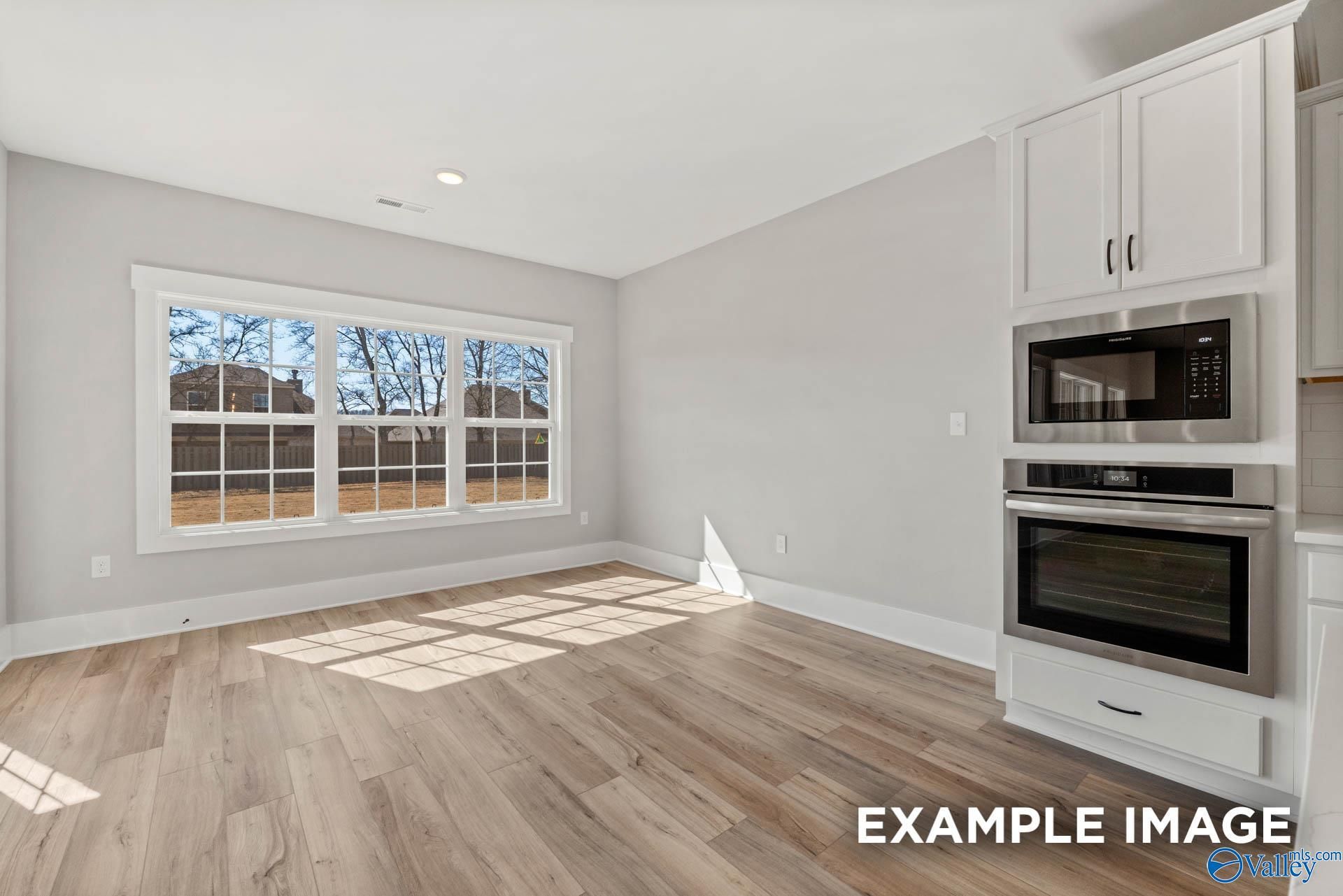 Bright dining area with wood-look flooring and built-in stainless steel appliances in The Finleigh, Briercreek, Meridianville.
