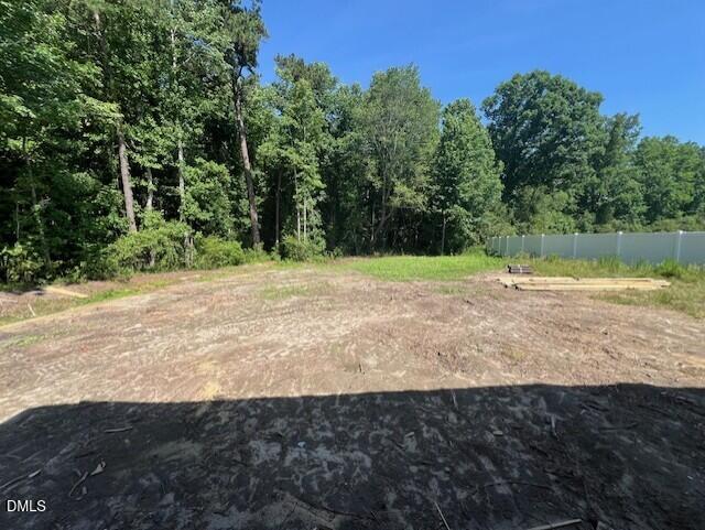 Spacious backyard lot at The Franklin C home in Wellers Knoll, Lillington, North Carolina, featuring mature tree views.