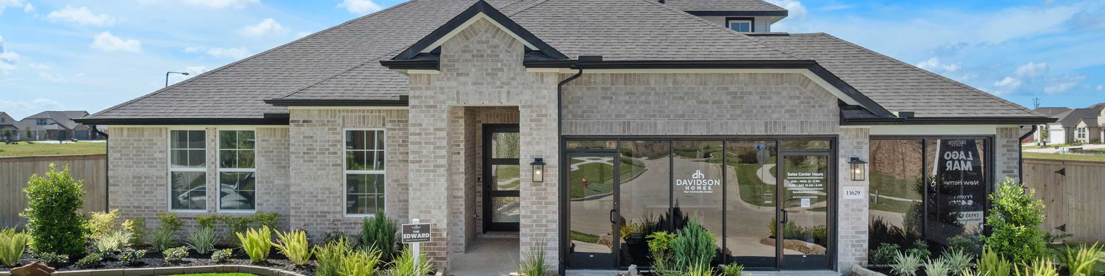 Modern brick ranch-style home exterior at Lago Mar in Texas City, Texas with covered porch, large windows, and lush landscaped yard