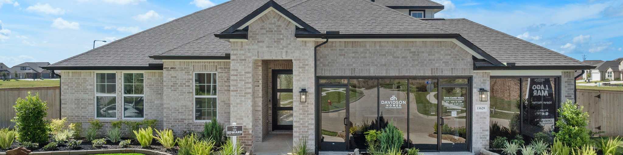 Modern brick ranch-style home exterior at Lago Mar in Texas City, Texas with covered porch, large windows, and lush landscaped yard