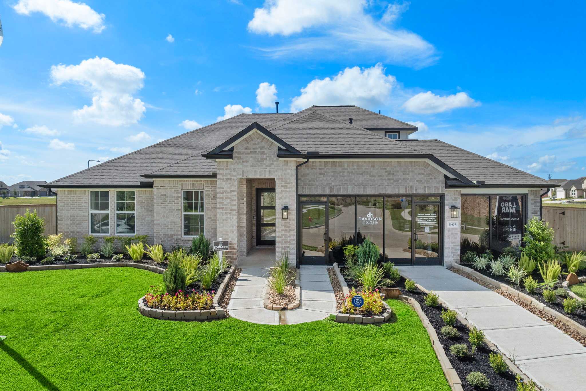 Contemporary brick home exterior at Lago Mar in Texas City, Texas by Davidson Homes with covered porch, large windows, and landscaped yard