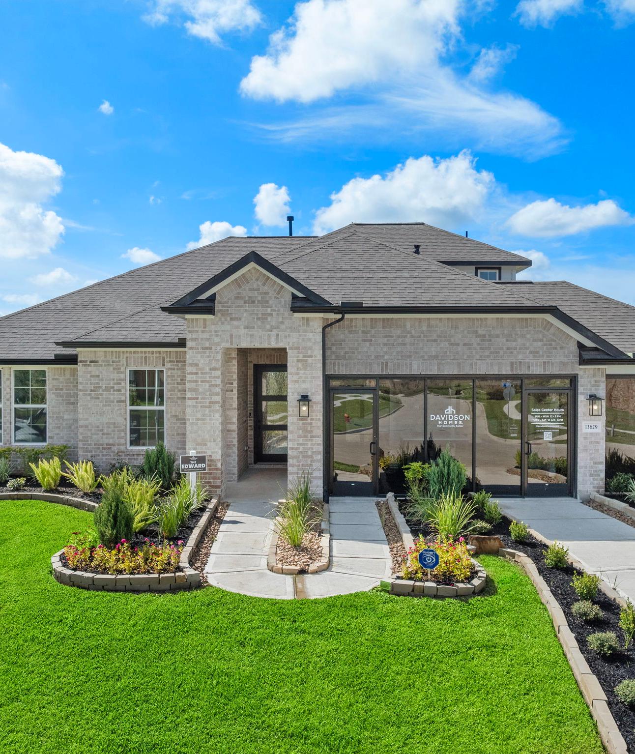 Modern brick ranch-style home exterior at Lago Mar in Texas City, Texas with covered porch, large windows, and lush landscaped yard