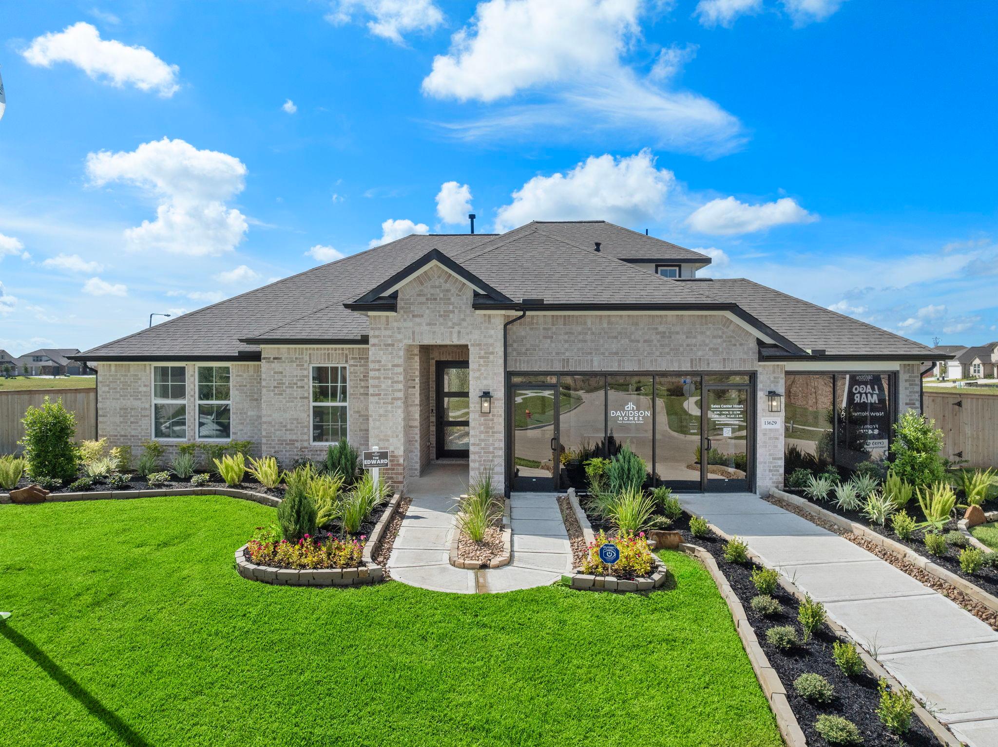 Modern brick ranch-style home exterior at Lago Mar in Texas City, Texas with covered porch, large windows, and lush landscaped yard