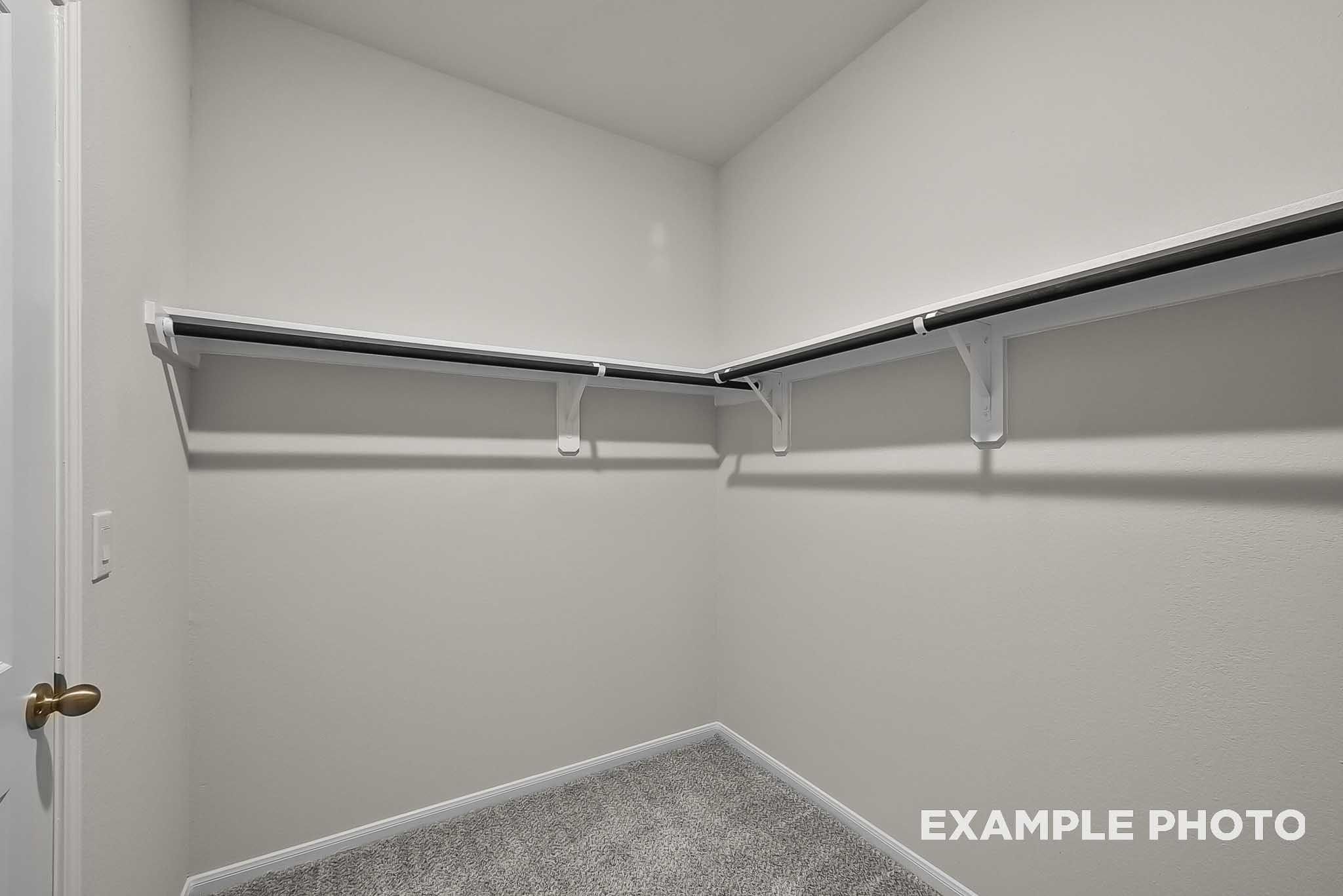 Spacious walk-in closet with shelving in The Blanco F floor plan at Spring Branch Crossing in Conroe, Texas.