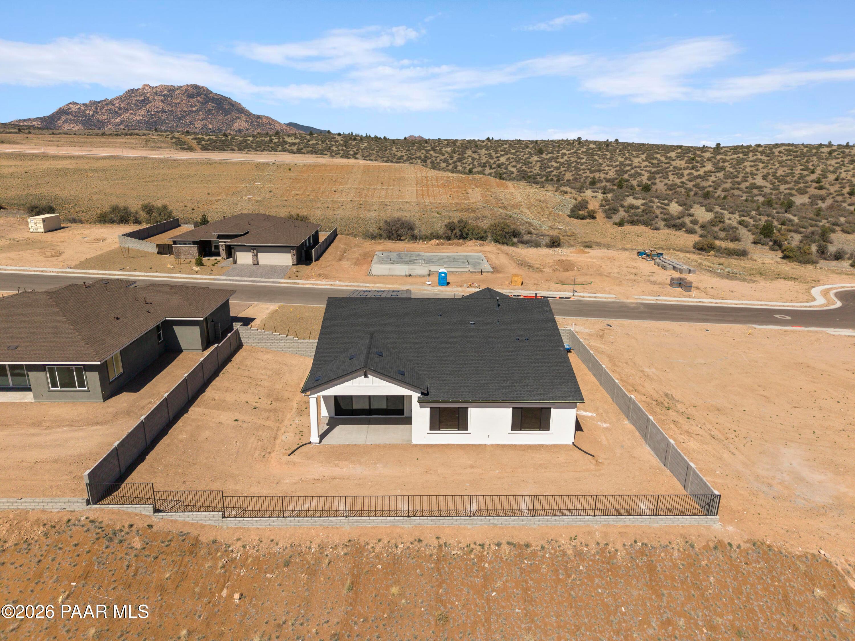 Aerial view of Soleil E single-story home by Davidson Homes in Hidden Hills, Prescott AZ, with fenced yard amid desert mountains