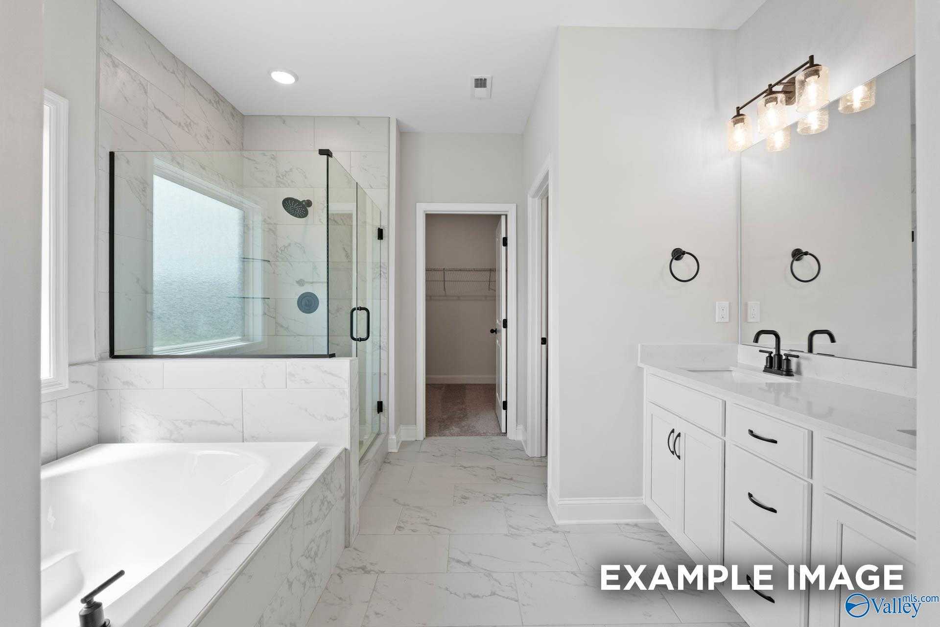 Luxurious master bathroom with glass shower, freestanding tub, and double vanity in Davidson Homes The Rockford, Decatur, AL